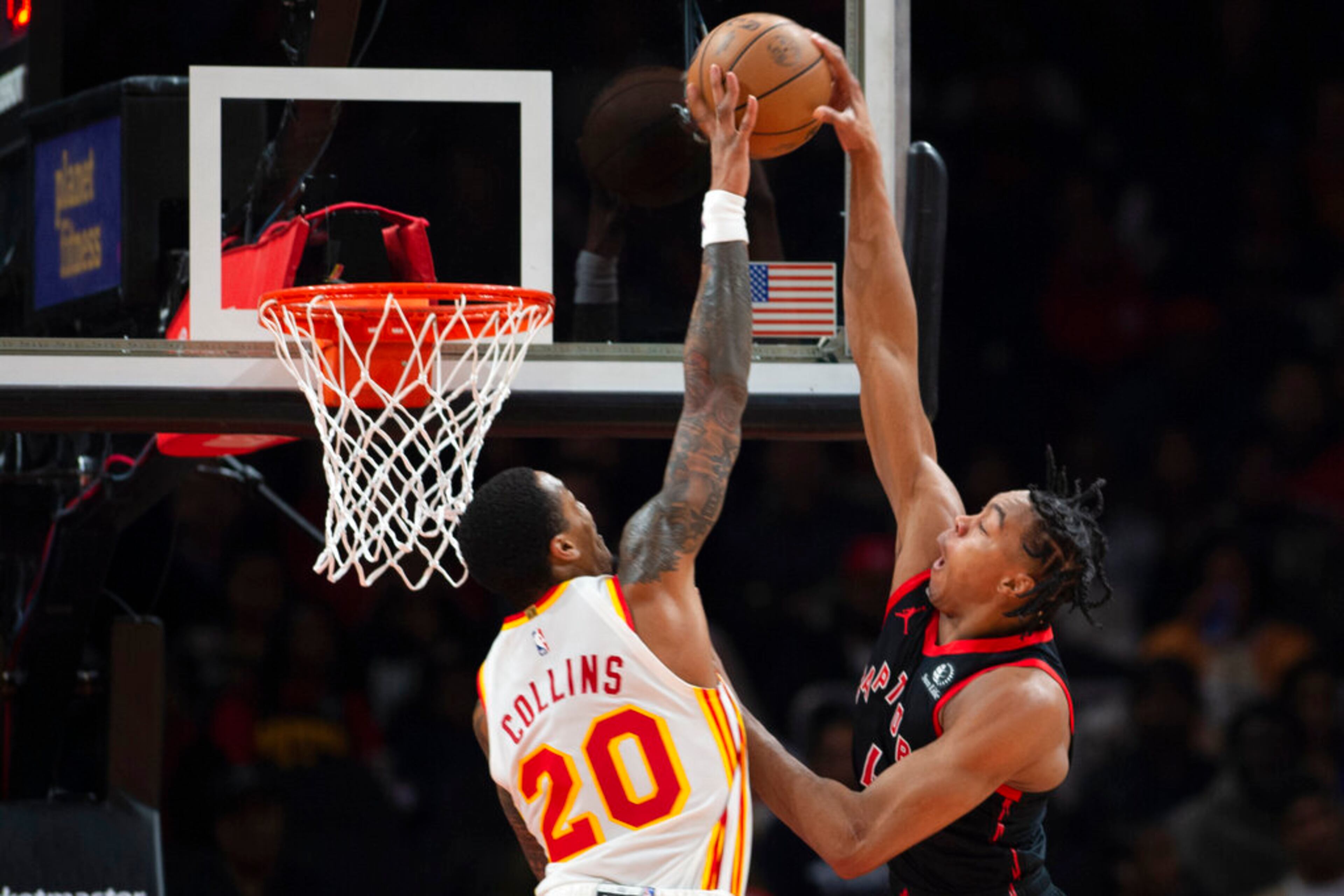 Toronto Raptors forward Scottie Barnes scores over Atlanta Hawks forward John Collins during the first half of an NBA basketball game, Saturday, Nov. 19, 2022, in Atlanta. (AP Photo/Hakim Wright Sr.)