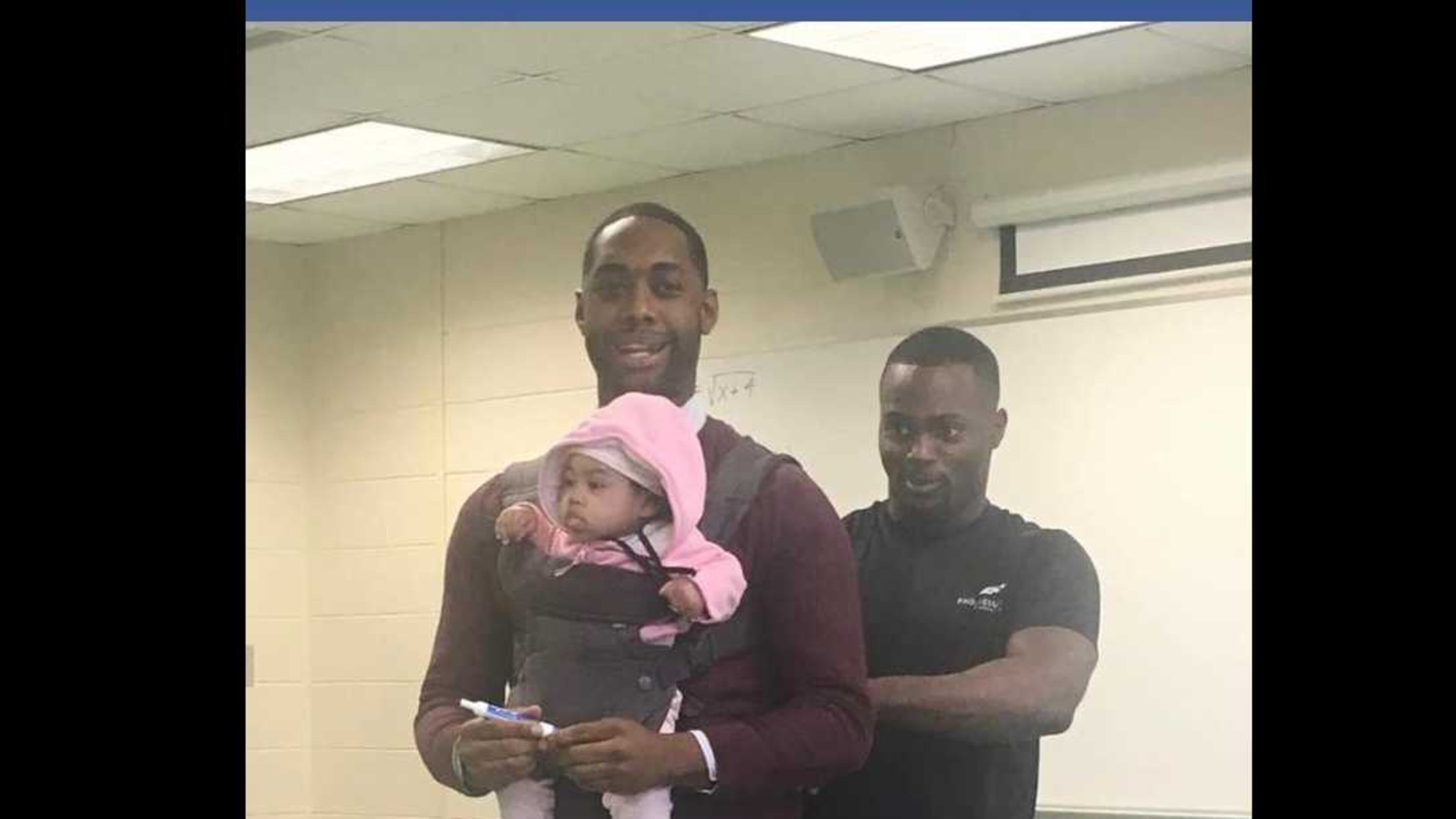 Morehouse College visiting professor Nathan Alexander volunteered to watch the child he's holding when his student, Wayne Hayer, right, could not find childcare before Alexander's class on Friday, March 1, 2019. PHOTO CONTRIBUTED.