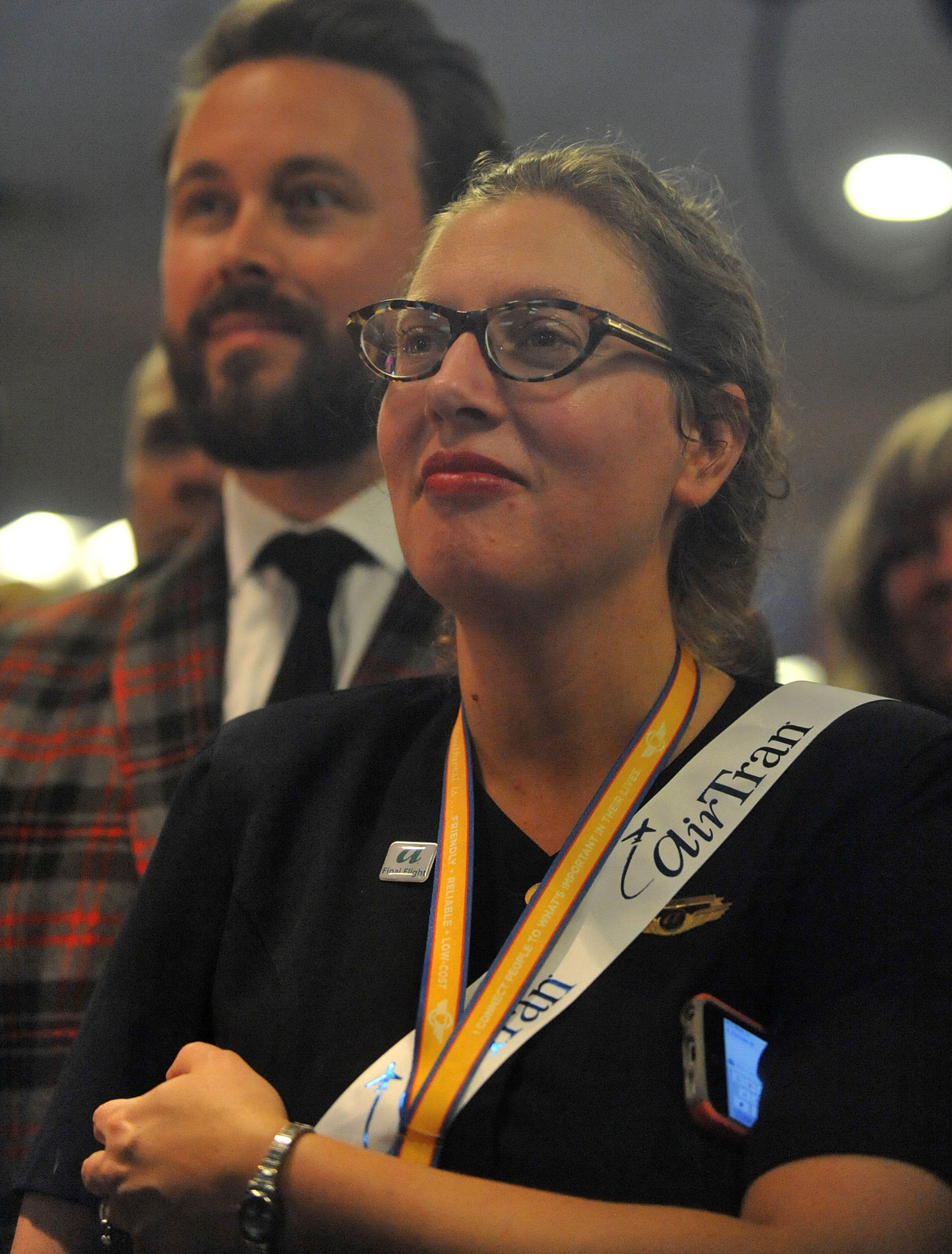 Flight attendant Sarah Wilson listens to official remarks. Hundreds of Southwest Airlines and former AirTran Airways employees gathered at Concourse C, gates 1, 2 and 3 to celebrate the departure of AirTran’s final flight to Tampa, at Hartsfield-Jackson International Airport, Sunday, December 28, 2014. Southwest CEO Gary Kelly and executives Bob Jordan and Jack Smith gave remarks during the program. The full flight was waved off by employees that gathered on the tarmac as crash trucks from Atlanta Fire Rescue gave a final water cannon salute as the plane departed. KENT D. JOHNSON/KDJOHNSON@AJC.COM