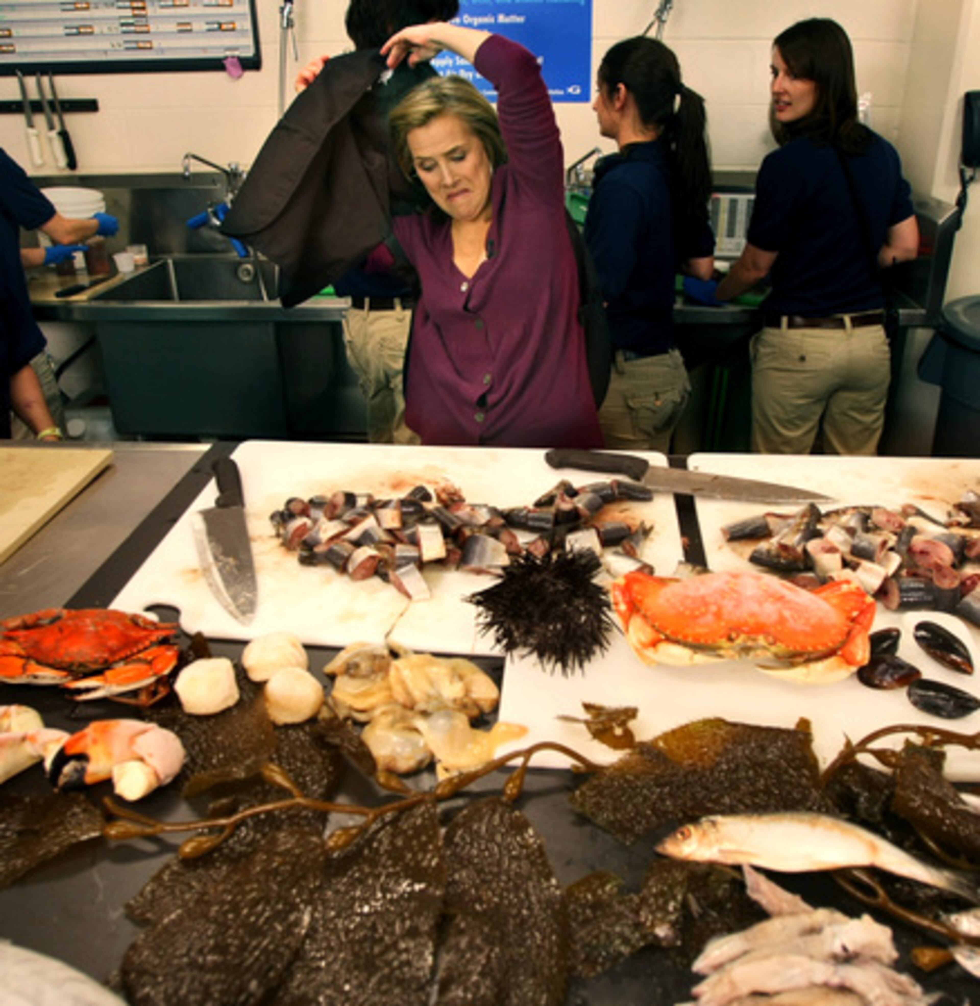Meredith Vieira takes off her husbandry attire in the commissary Tuesday after cutting up some fish with Al Roker.