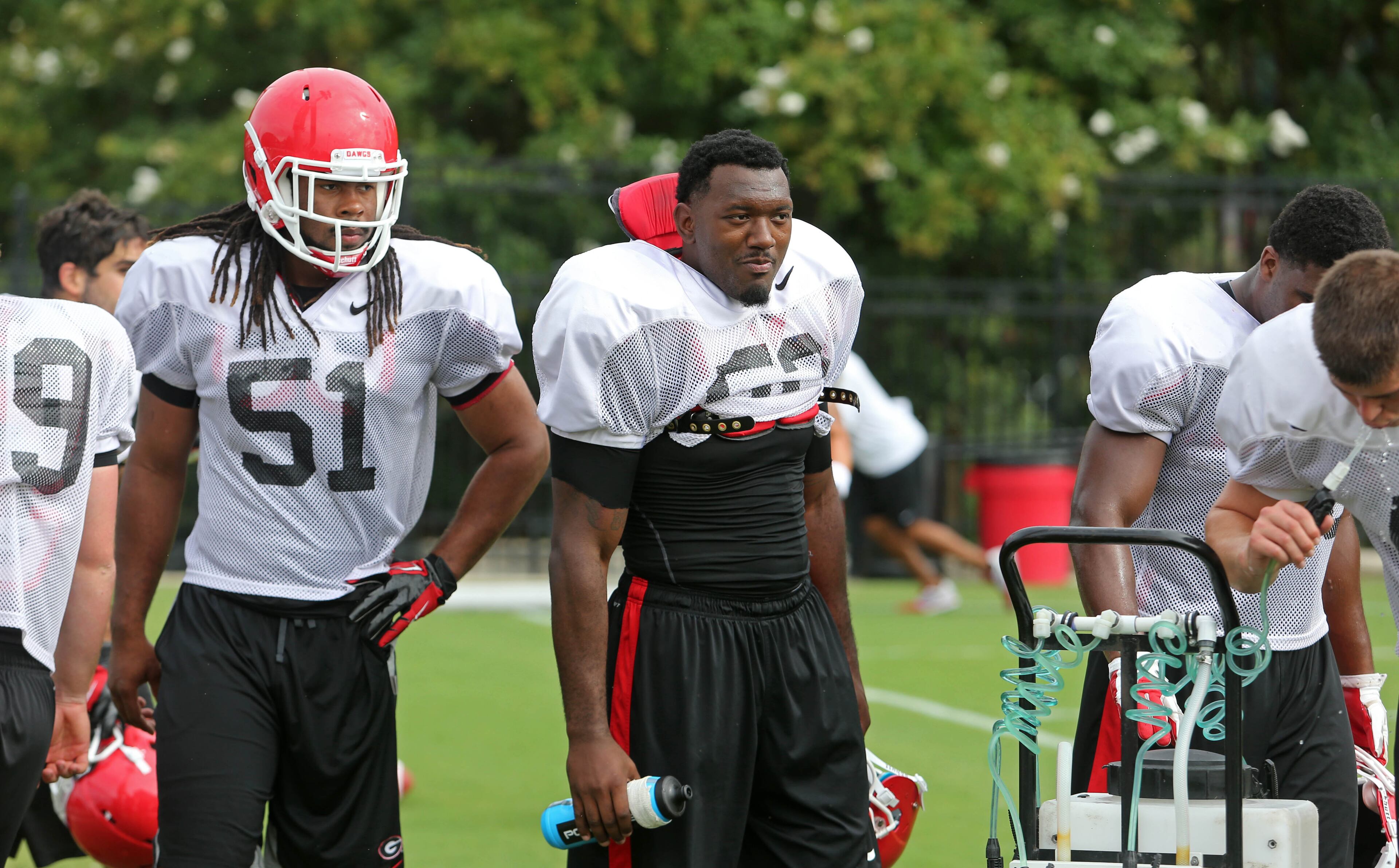 University of Georgia linebackers Ramik Wilson (51) and Amarlo Herrera, center, take a water break during preseason football practice at the University of Georgia Thursday afternoon in Athens, Ga., August 15, 2013. JASON GETZ / JGETZ@AJC.COM