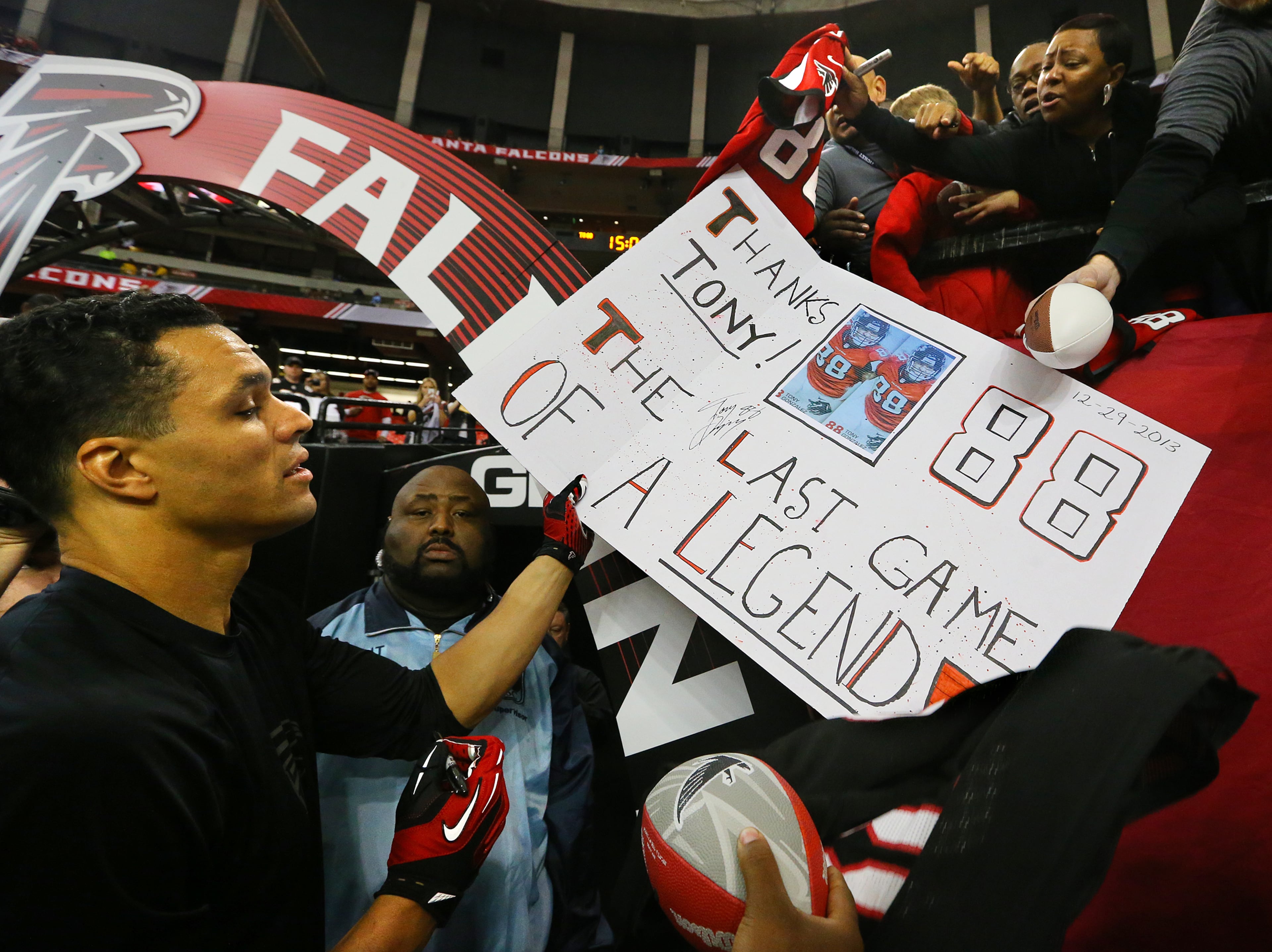 Falcons tight end Tony Gonzalez signs autographs for fans before playing the final game of his 17-year NFL career against the Panthers on Sunday, Dec. 29, 2013, in Atlanta.