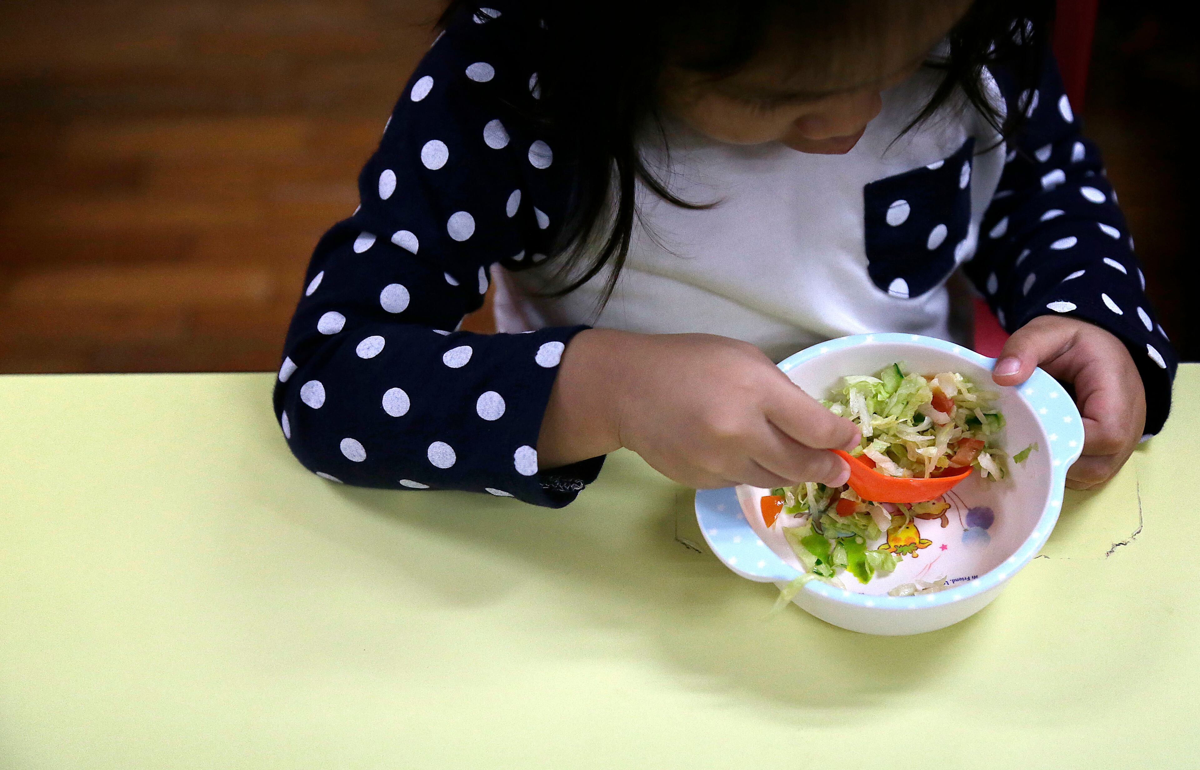 A child eats her salad and soup for lunch on Tuesday, May 6, 2014 at Delcare Edu Center, a local kindergarten and child care center in the business district of Singapore. Everyday, lunch is prepared by the school kitchen staff and efforts to promote healthy eating in this particular center is seen in painstaking efforts in selection of their ingredients and food preparation methods. The children in this school are also taught to accept a wide variety of food, and the principal plans a weekly menu at the start of each school term. Healthy snacks consisting of fruits, home-made bread, natural beans, soup, and barley are served between meals. (AP Photo/Wong Maye-E)