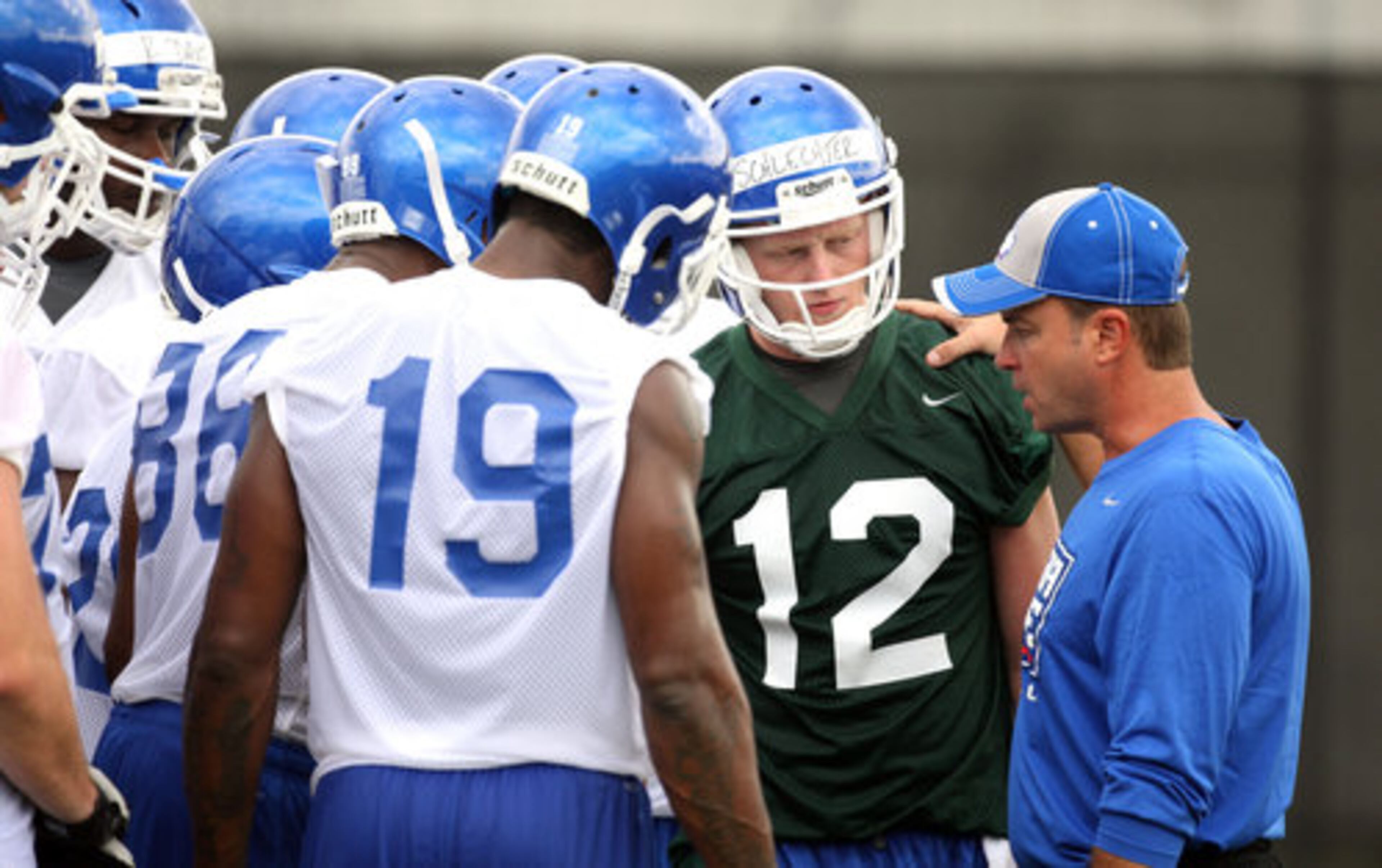 Georgia State University starting quarterback Bo Schlechter (12) listens to offensive coordinator/quarterbacks coach John Bond talk to wide receiver Sidney Haynes (19) and others in the huddle during GSU's first practice at the GSU Football Practice Complex Thursday morning in Atlanta, Ga., August 4, 2011. Schlechter is the only available quarterback with experience since 2010 starter Drew Little will be suspended for the first four games.