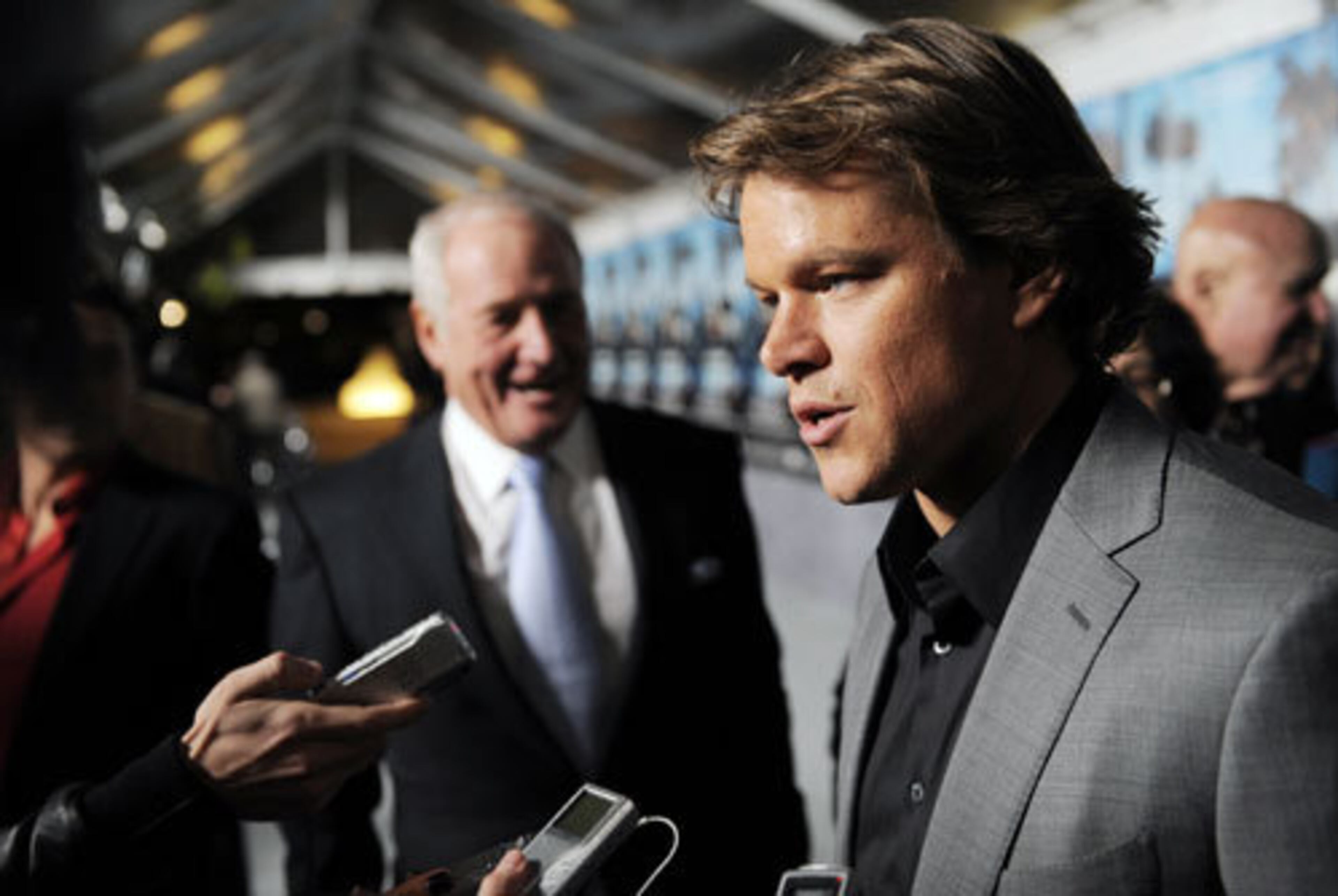 Matt Damon speaks to reporters as Jerry Weintraub looks on.