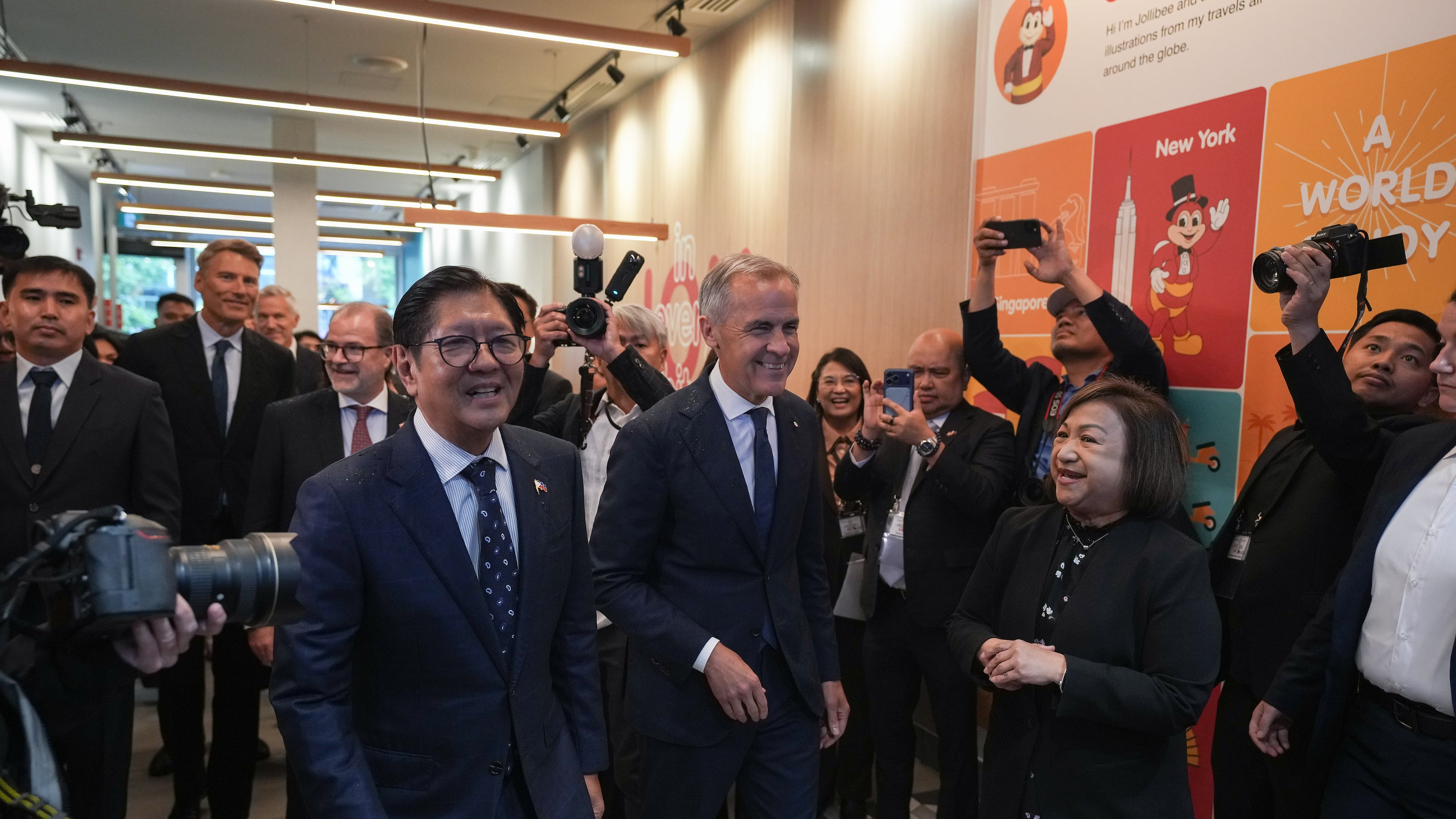 Canada's Prime Minister Mark Carney, center, and Philippines President Ferdinand Marcos Jr., right, arrive for a visit to a Jollibee fast food restaurant, in Vancouver, Thursday, July 2, 2026. (Darryl Dyck/The Canadian Press via AP)