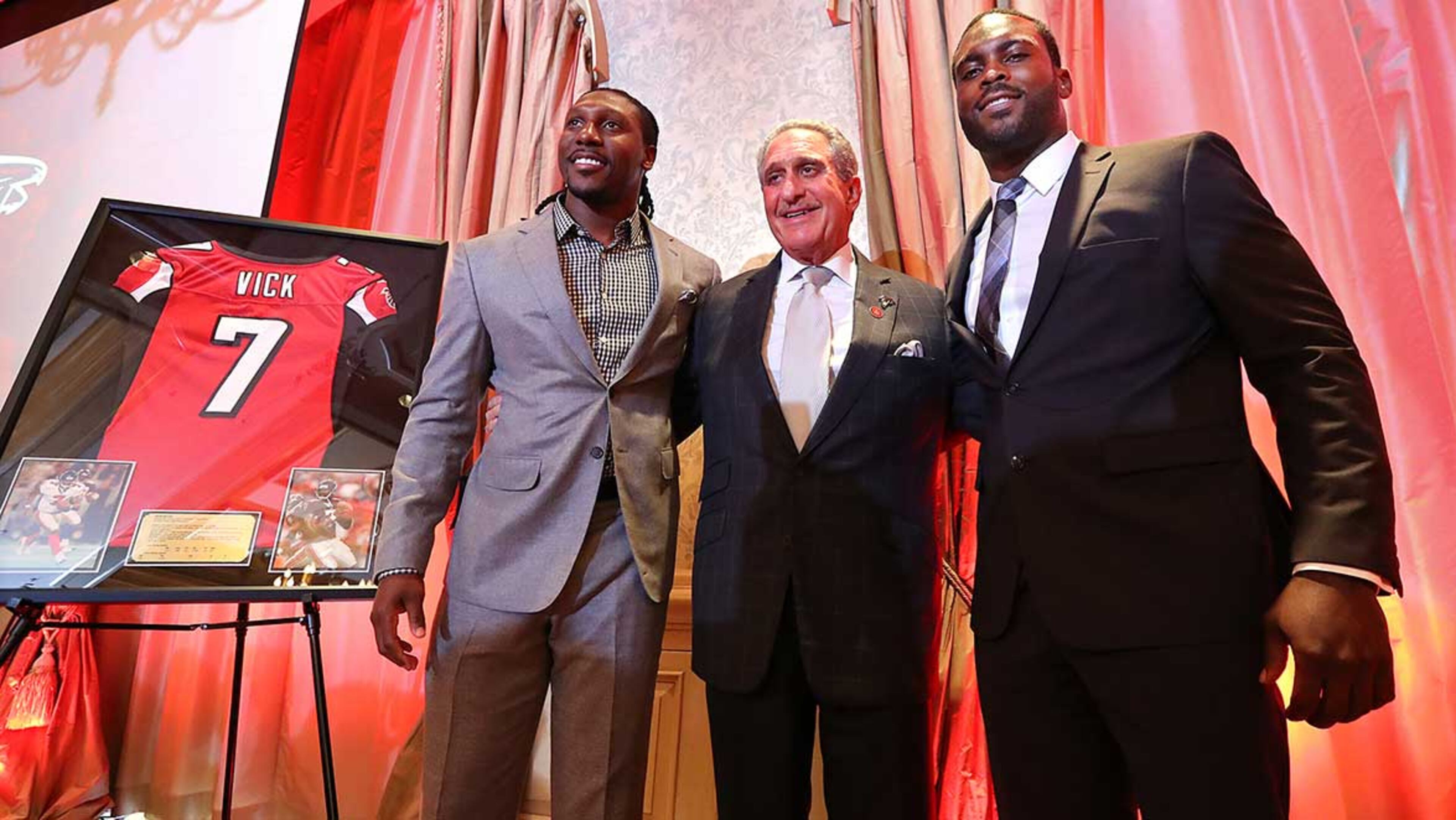 Atlanta Falcons owner Arthur Blank honors former Falcons quarterback Michael Vick (right) and wide receiver Roddy White as they officially retire from the NFL on Monday in Atlanta.