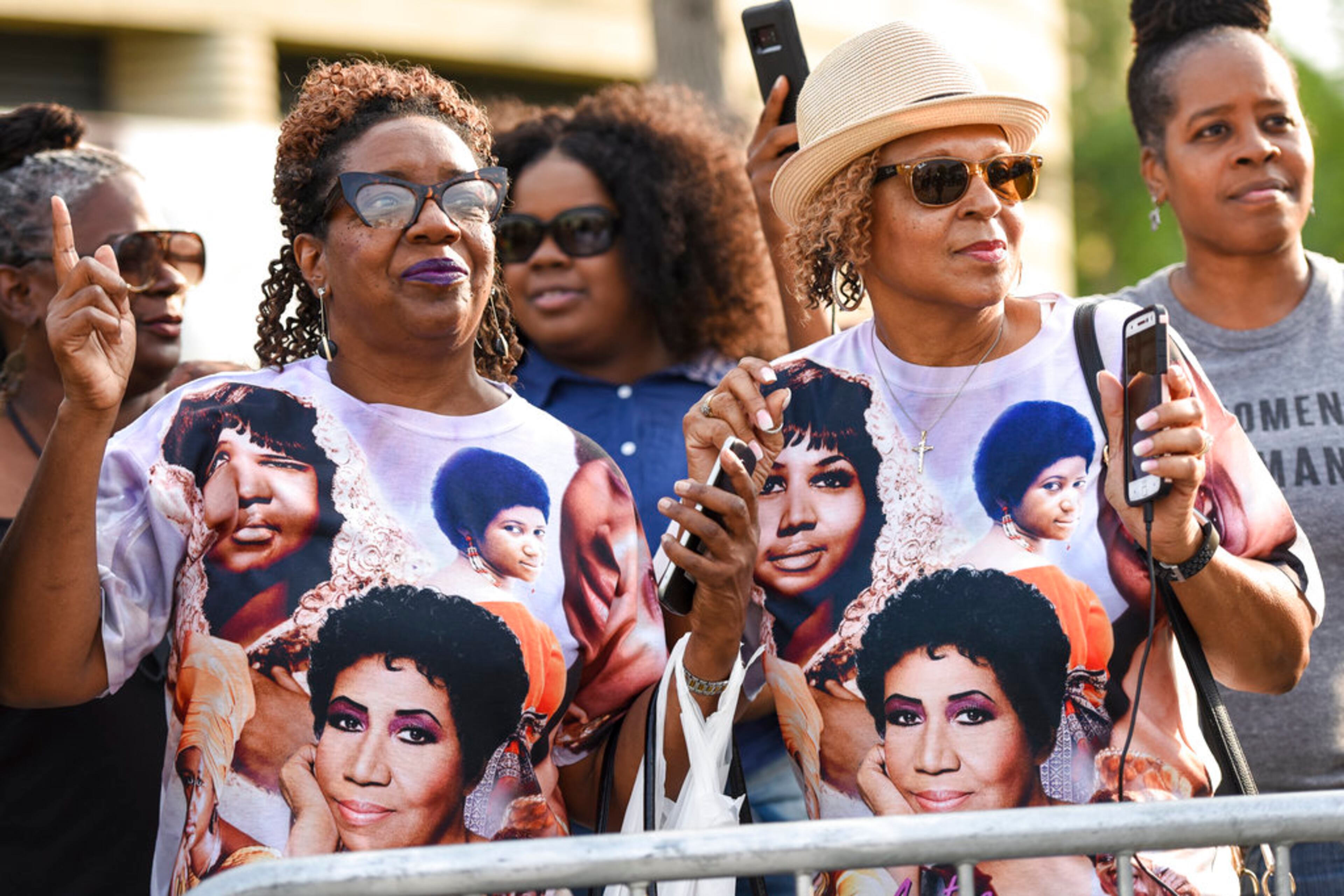 Rochelle Hampton, left, of Warren, Mich., and Imogen King-Dugan, of Farmington Hills, Mich, dance along to "Freeway of Love" being played from a cell phone after a 1956 pink Cadillac pulled up to Charles H. Wright Museum of African American History in Detroit during the public viewing for legendary singer Aretha Franklin Tuesday, Aug. 28, 2018. Thousands are expected to pour into Detroit's Charles H. Wright Museum of African American History on Tuesday and Wednesday to pay their final respects to Franklin. (Tanya Moutzalias/Ann Arbor News-MLive.com via AP)