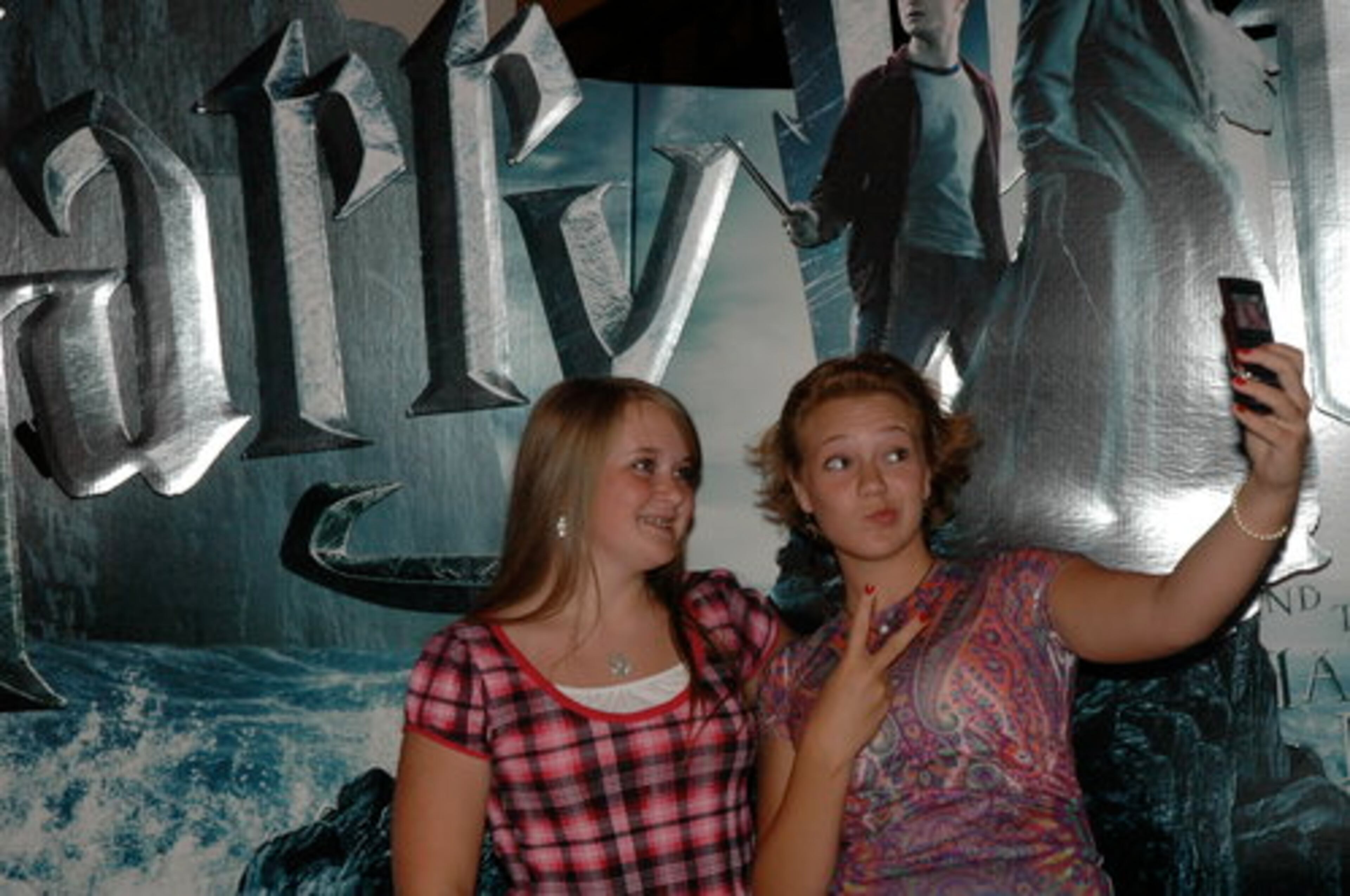 Mary Kate Halpin, 13, of Flowery Branch, and Jordan Davis, 13, of Buford, posted before a Harry Potter sign at Regal Mall of Georgia Thursday before an early showing of "Harry Potter and the Half-Blood Prince." Halpin is a movie lover and Davis swears she's read the entire Potter series seven times.