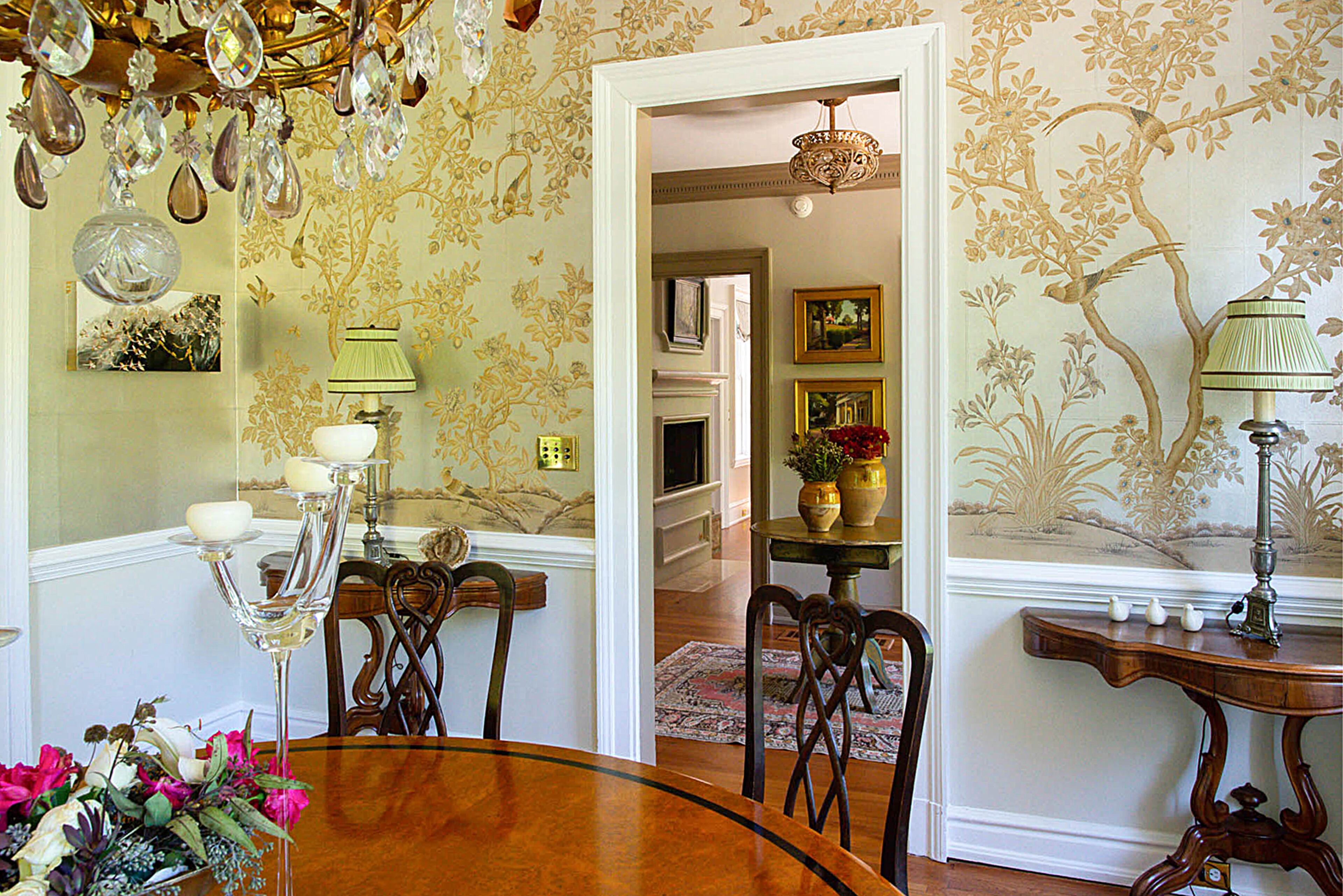 Hand-painted chinoiserie Gracie wallpaper lends the dining room to an Asian design.