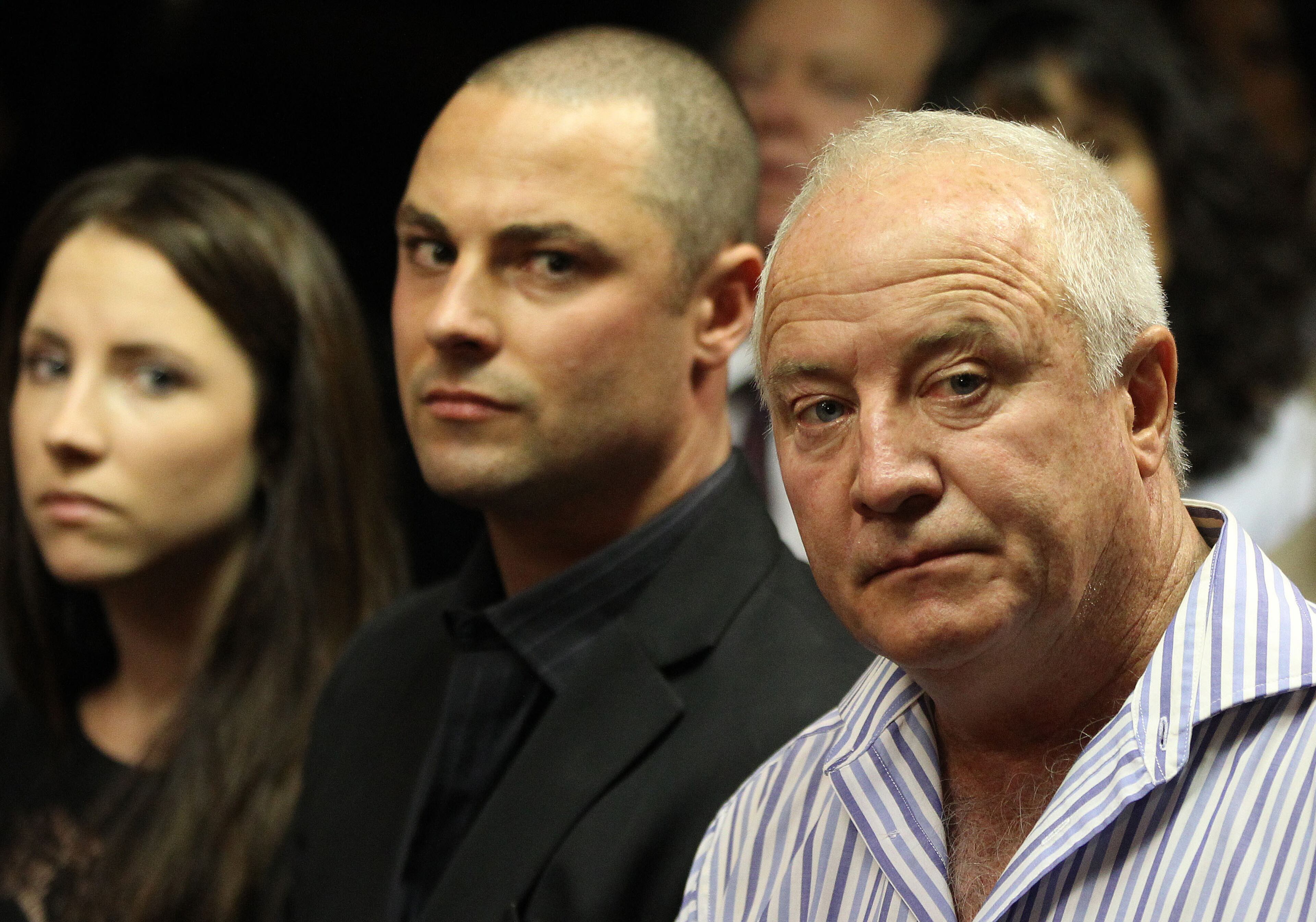 Olympic athlete Oscar Pistorius' father Henke Pistorius, right, with his children Carl, center,, and Aimee, left, watch as Oscar Pistorius walks in during his bail hearing at the magistrate court in Pretoria, South Africa, Friday, Feb. 22, 2013. (AP Photo/Themba Hadebe)