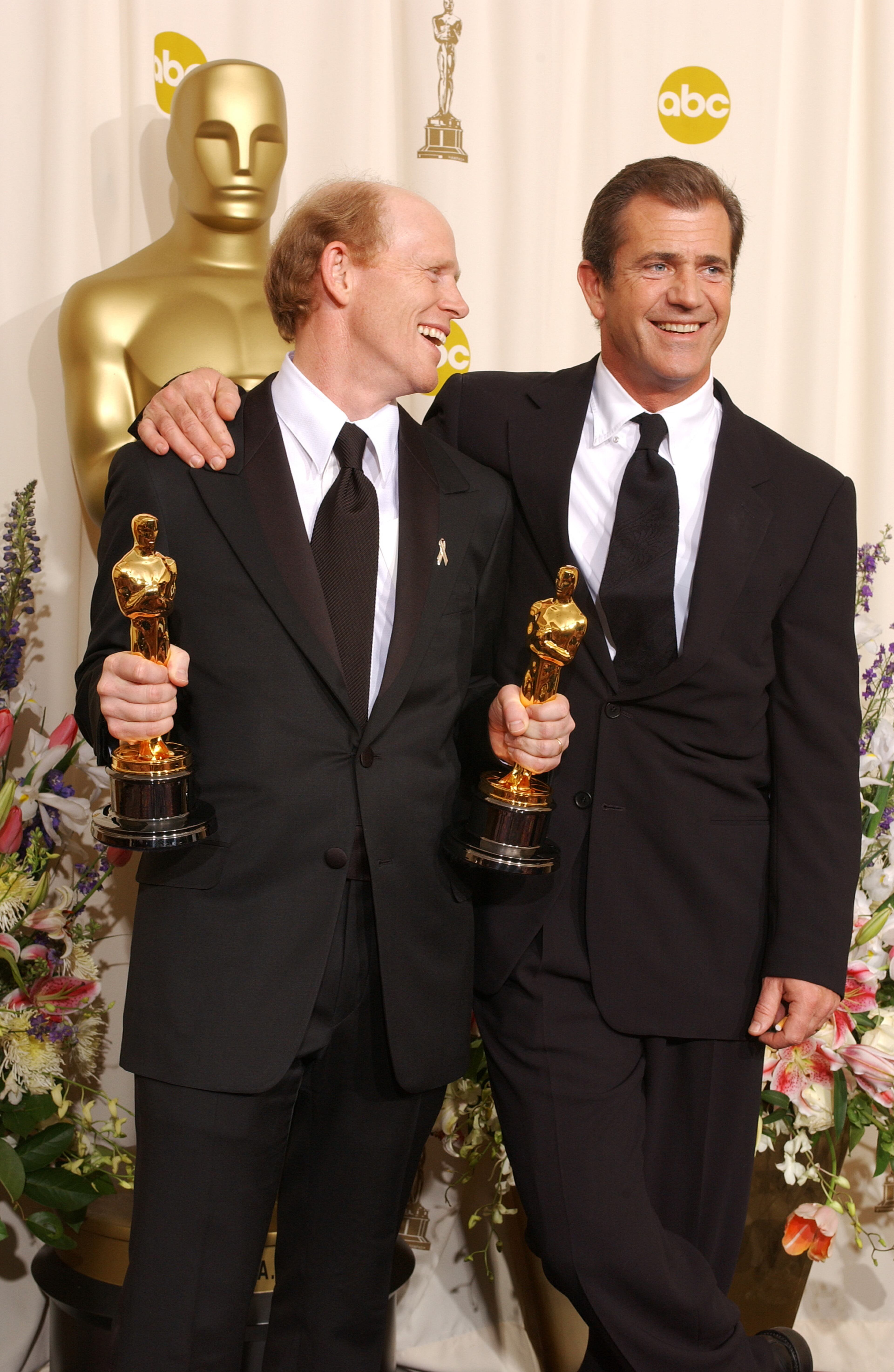 Director Ron Howard, holding two Oscars for his wins in the categories of Best Director and Best Picture for A Beautiful Mind, poses with presenter Mel Gibson for photographers backstage at the 74th Annual Academy Awards in Los Angeles, CA at the Kodak Theater on March 24, 2002. Photo credit: Frank Micelotta/ImageDirect