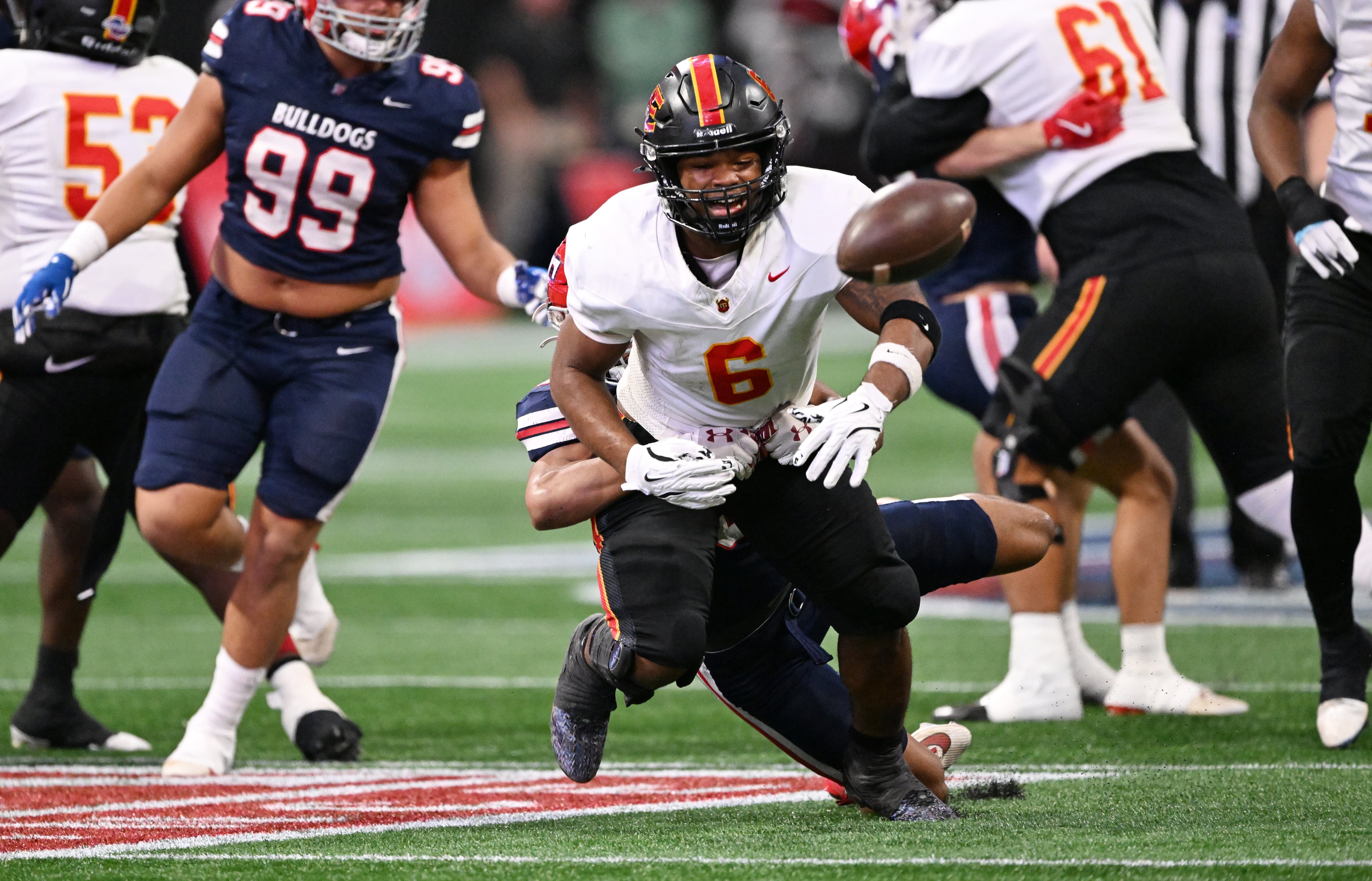 Northeast's running back Nick Woodford (6) fumble the ball as he gets tackled from behind by Toombs County's linebacker Hayden Roy (8) during the first half in GHSA Class A-Division State Championship game at Mercedes-Benz Stadium, Tuesday, December 17, 2024, in Atlanta. (Hyosub Shin / AJC)