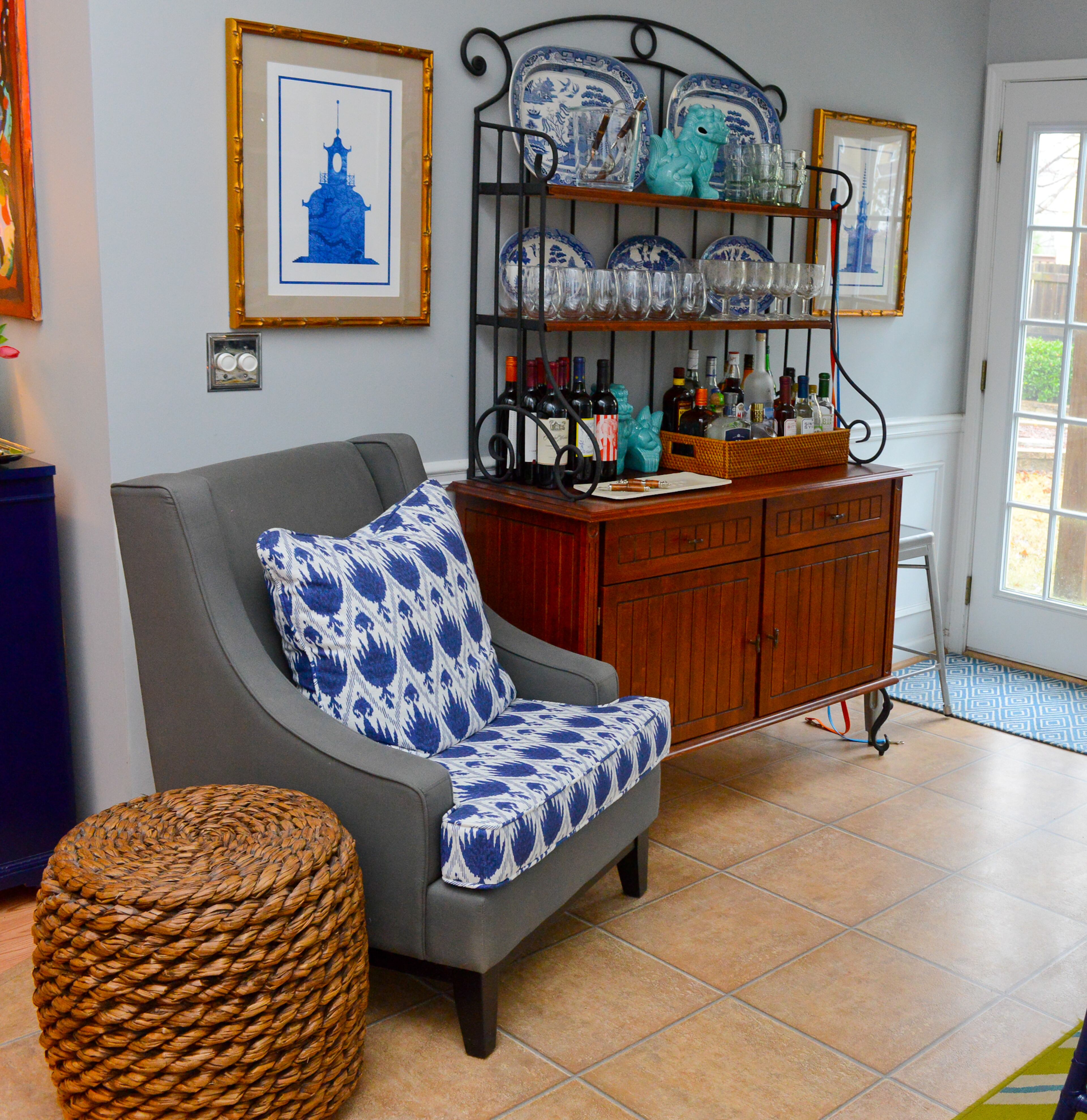 Opposite the table in the dining room, Travis Snyder uses classic blue in the pillows, artwork and accessories to fit with the home's Southern preppy interior design.