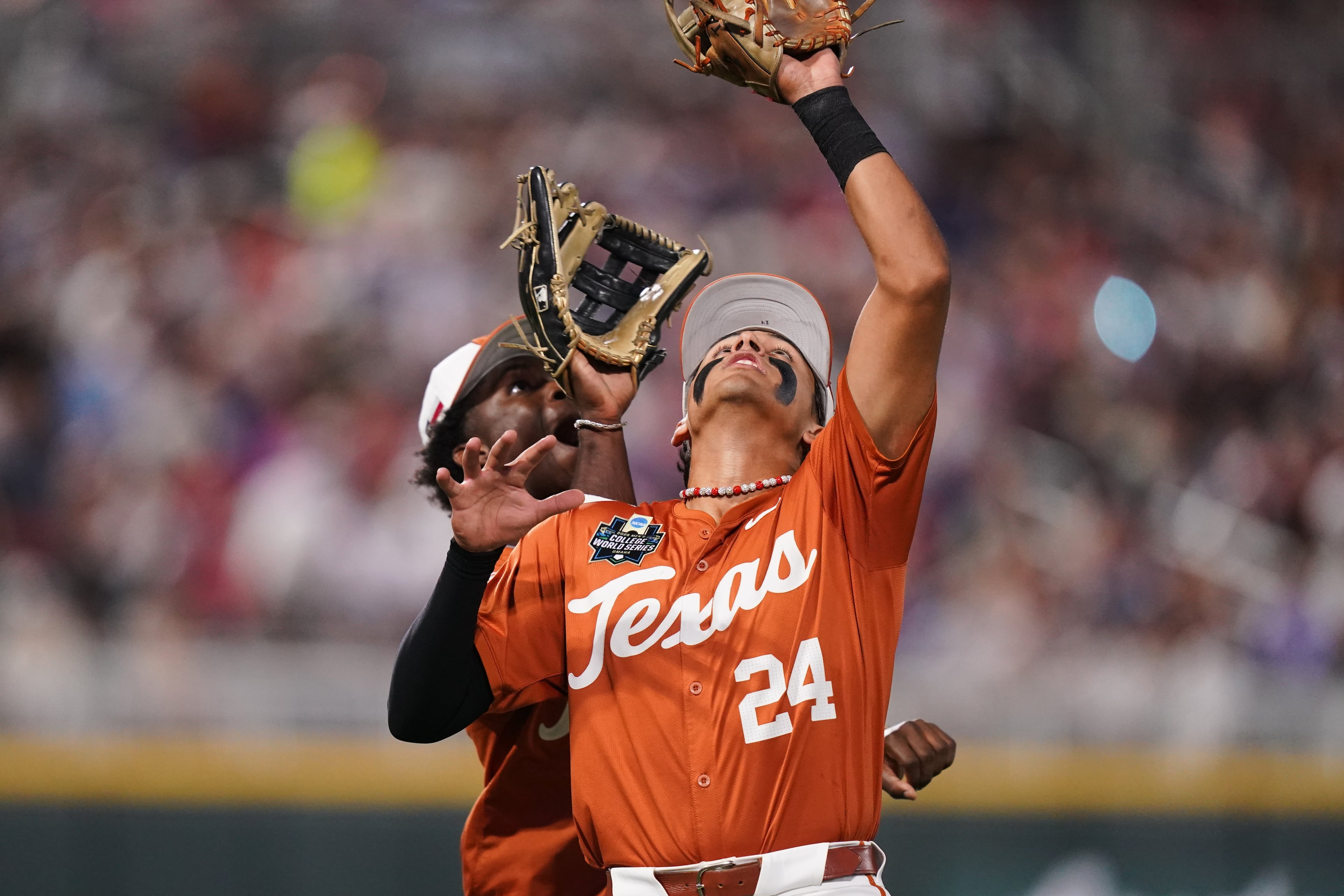 Texas infielder Adrian Rodriguez (24) makes the catch while colliding with outfielder Anthony Pack Jr. (6) during an NCAA baseball College World Series elimination game against Georgia, Tuesday, June 16, 2026 in Omaha, Neb. Georgia won 2-0. (AP Photo/Vera Nieuwenhuis)