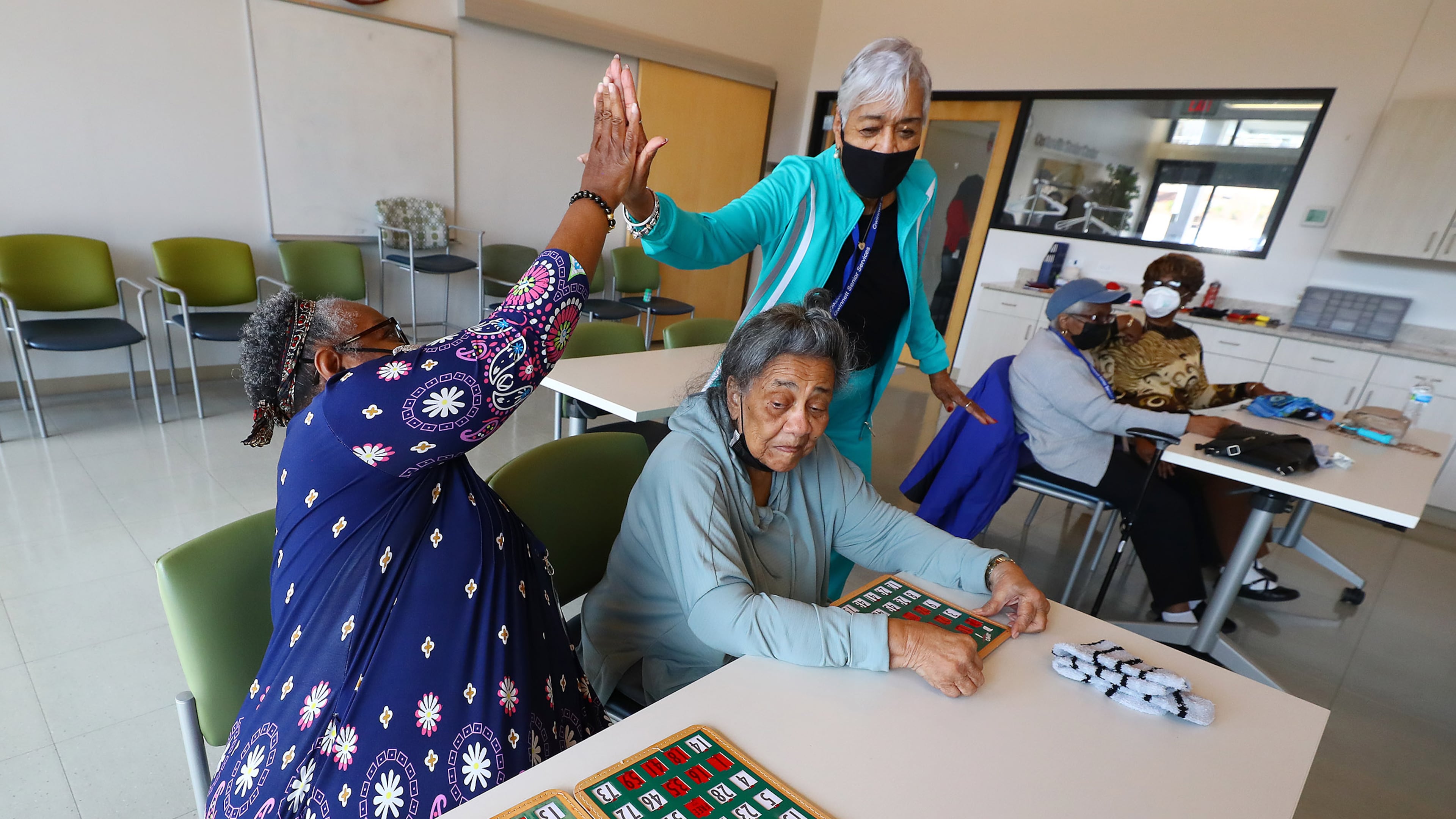 022422 Snellville: Bertha Flowers (left) gets five from Rose Golson after hitting bingo while playing at the Centerville Senior Center on Thursday, Feb. 24, 2022, in Snellville. Gwinnett County is expanding its Health and Human Services department and a future expansion will connect the senior center with another building. “Curtis Compton / Curtis.Compton@ajc.com”`
