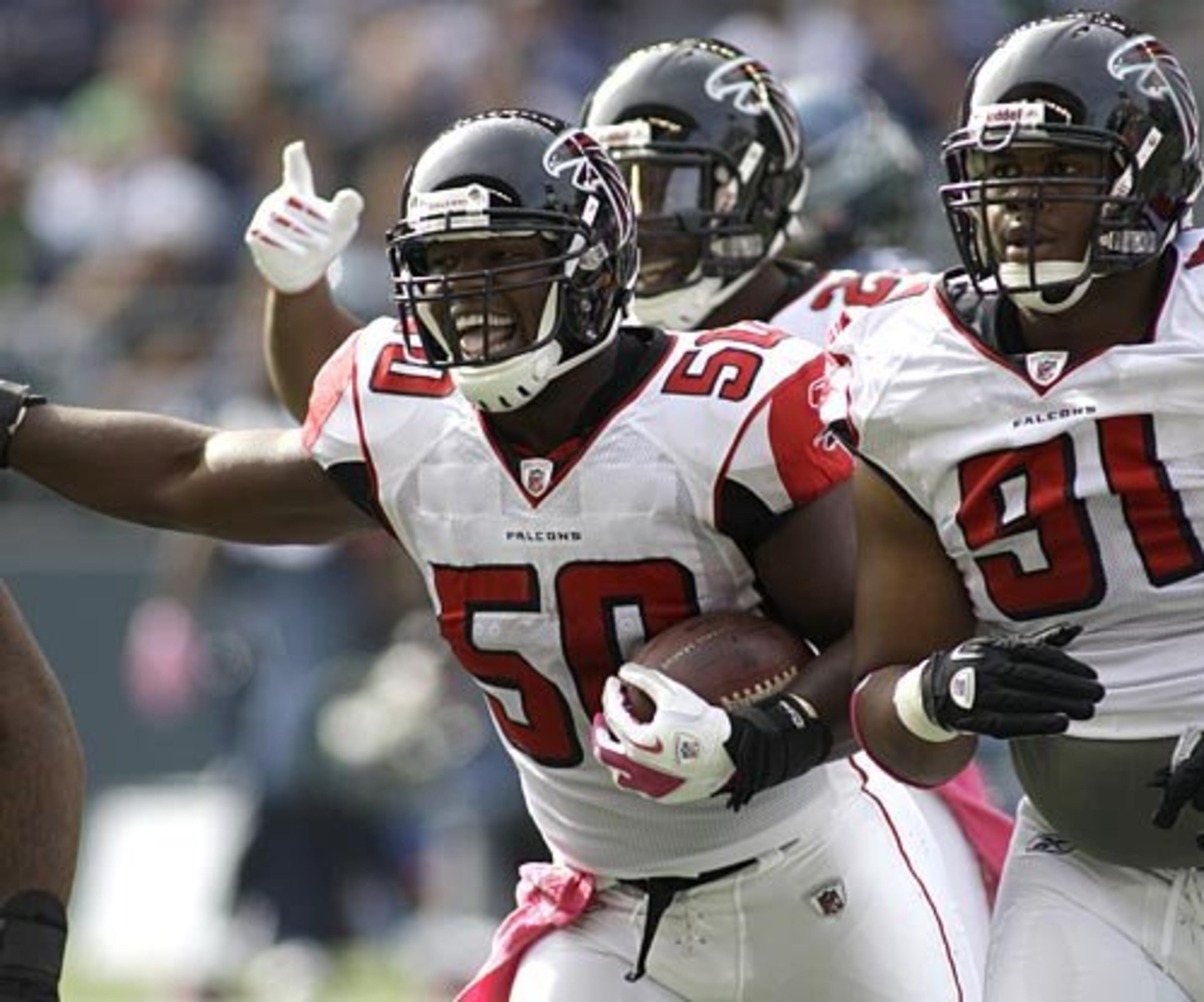 Curtis Lofton (50) celebrates his interception against the Seahawks along with the Falcons' Corey Peters, right.