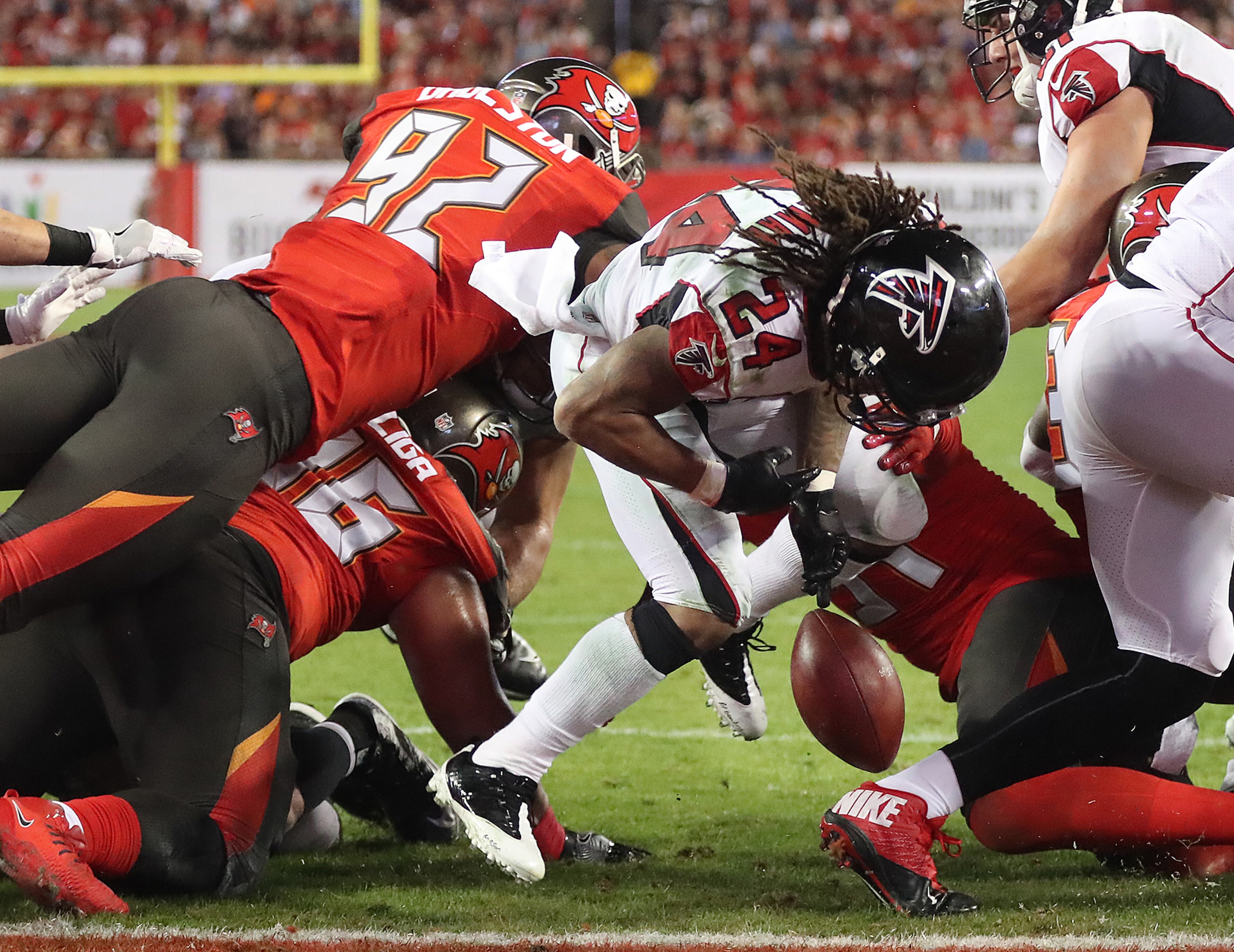 December 18, 2017 Tampa: Falcons running back Devonta Freeman fumbles into the endzone as he is hit by Buccaneers defenders, but tight end Levine Toilolo recovered for the Falcons to take a 14-7 lead over the Bucs during the second quarter in a NFL football game on Monday, December 18, 2017, in Tampa. Curtis Compton/ccompton@ajc.com