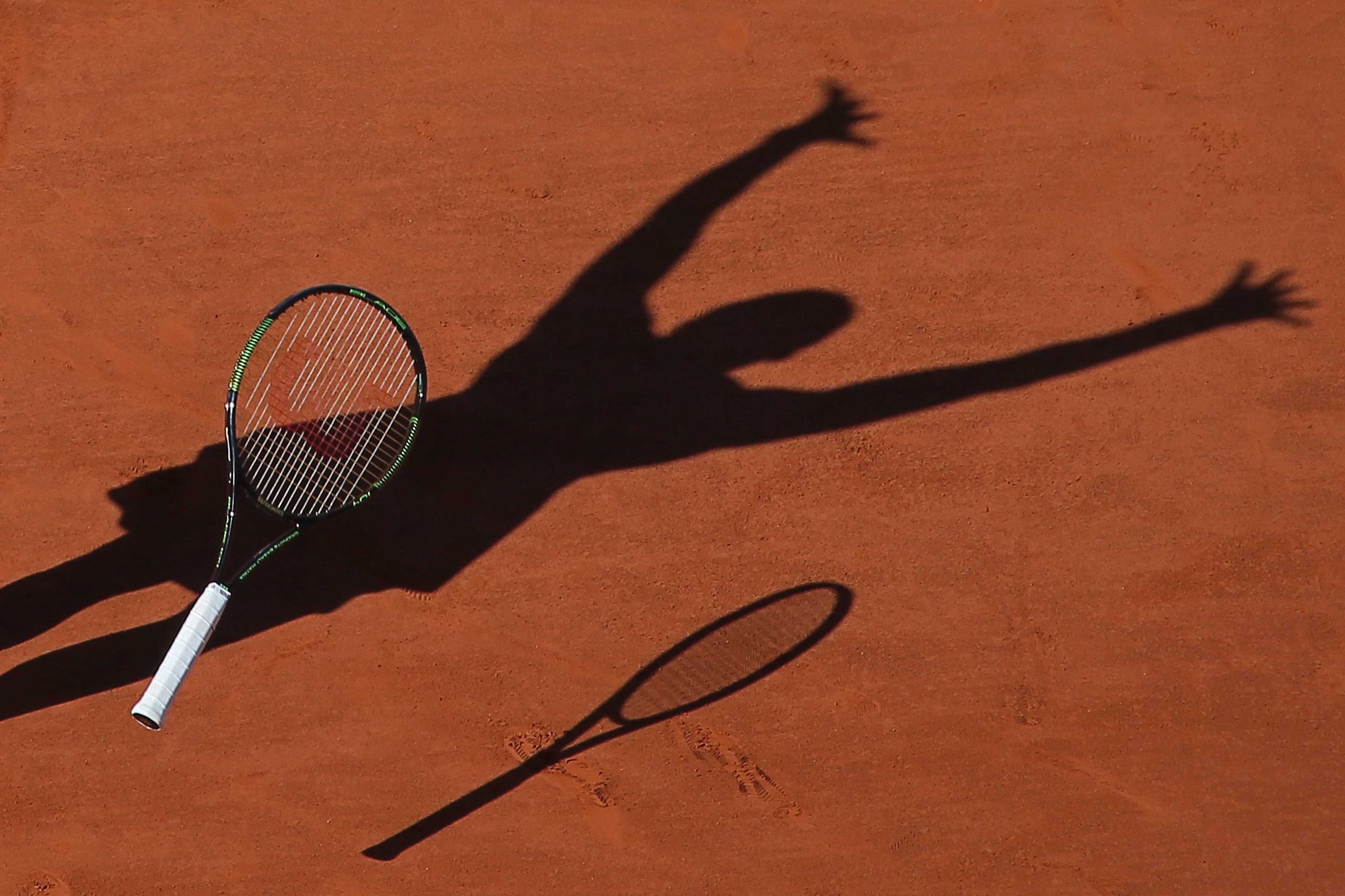 Serena Williams of the U.S. casts a shadow on the clay as she drops her racket while celebrating winning the final of the French Open tennis tournament against Lucie Safarova of the Czech Republic in three sets, 6-3, 6-7, 6-2, at the Roland Garros stadium, in Paris, France, Saturday, June 6, 2015. (AP Photo/David Vincent)