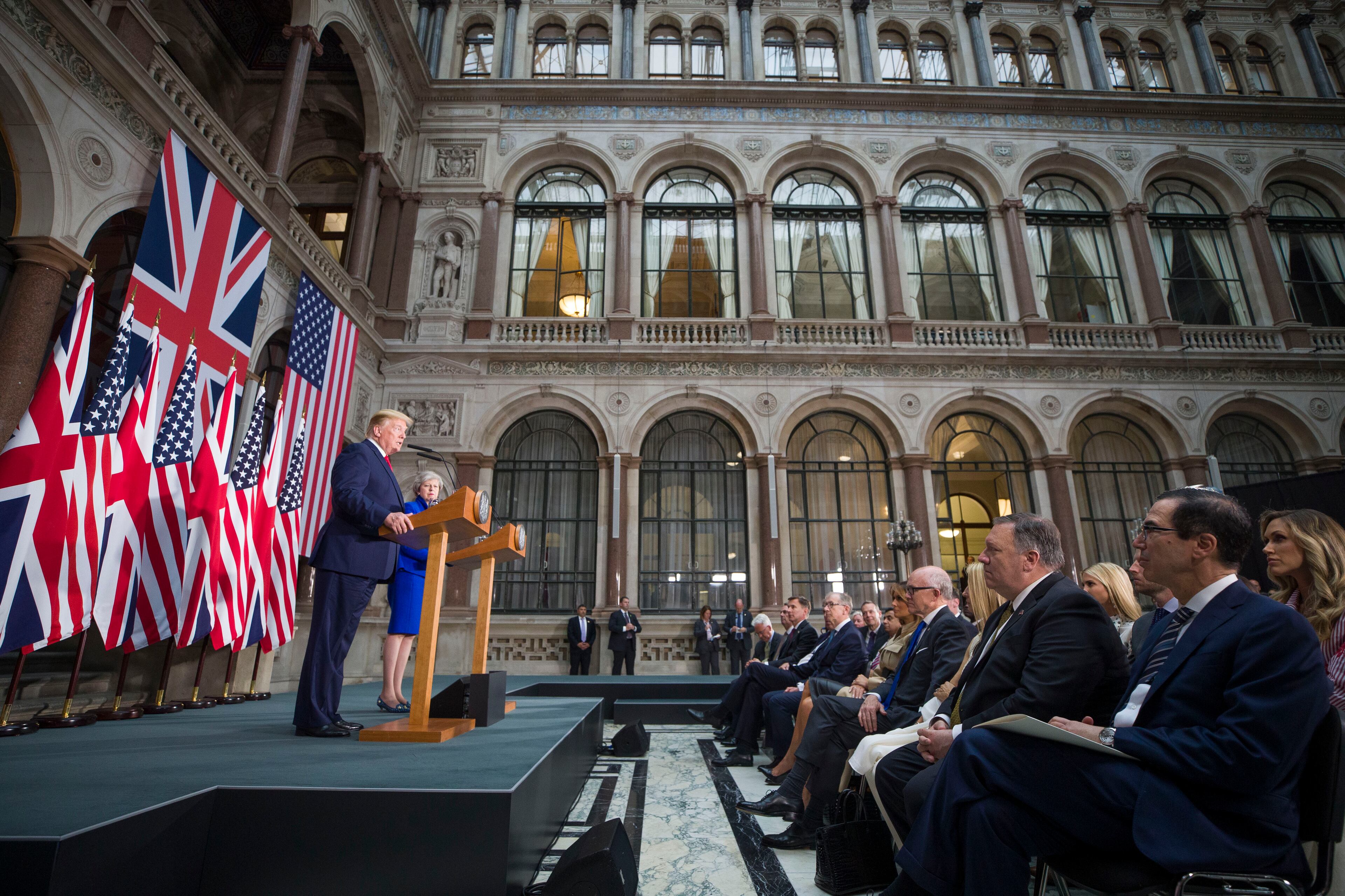 President Donald Trump speaks during a news conference with British Prime Minister Theresa May as Secretary of State Mike Pompeo, and Treasury Secretary Steve Mnuchin, right, are seated in the audience at the Foreign Office, Tuesday, June 4, 2019, in central London. (AP Photo/Alex Brandon)
