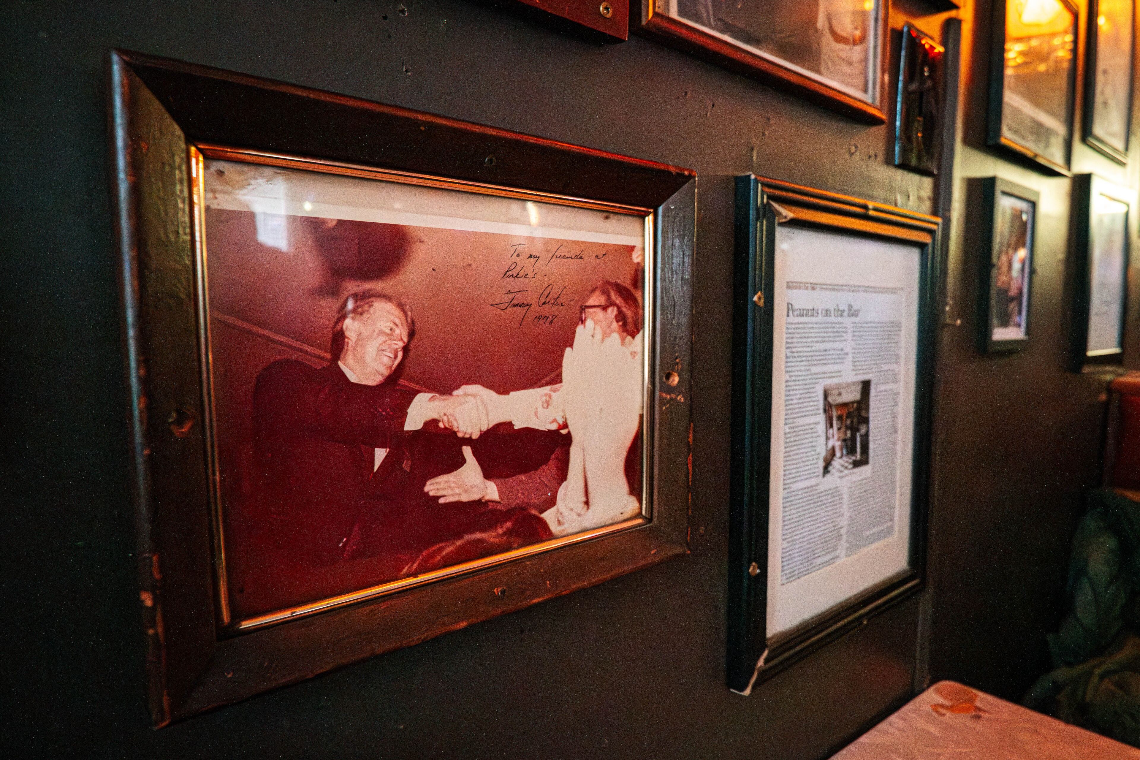 Photos and other memorabilia of former President Jimmy Carter adorn the walls of the Pinkie Masters bar in Savannah, GA on December 23, 2024. (Justin Taylor/The Atlanta Journal-Constitution)