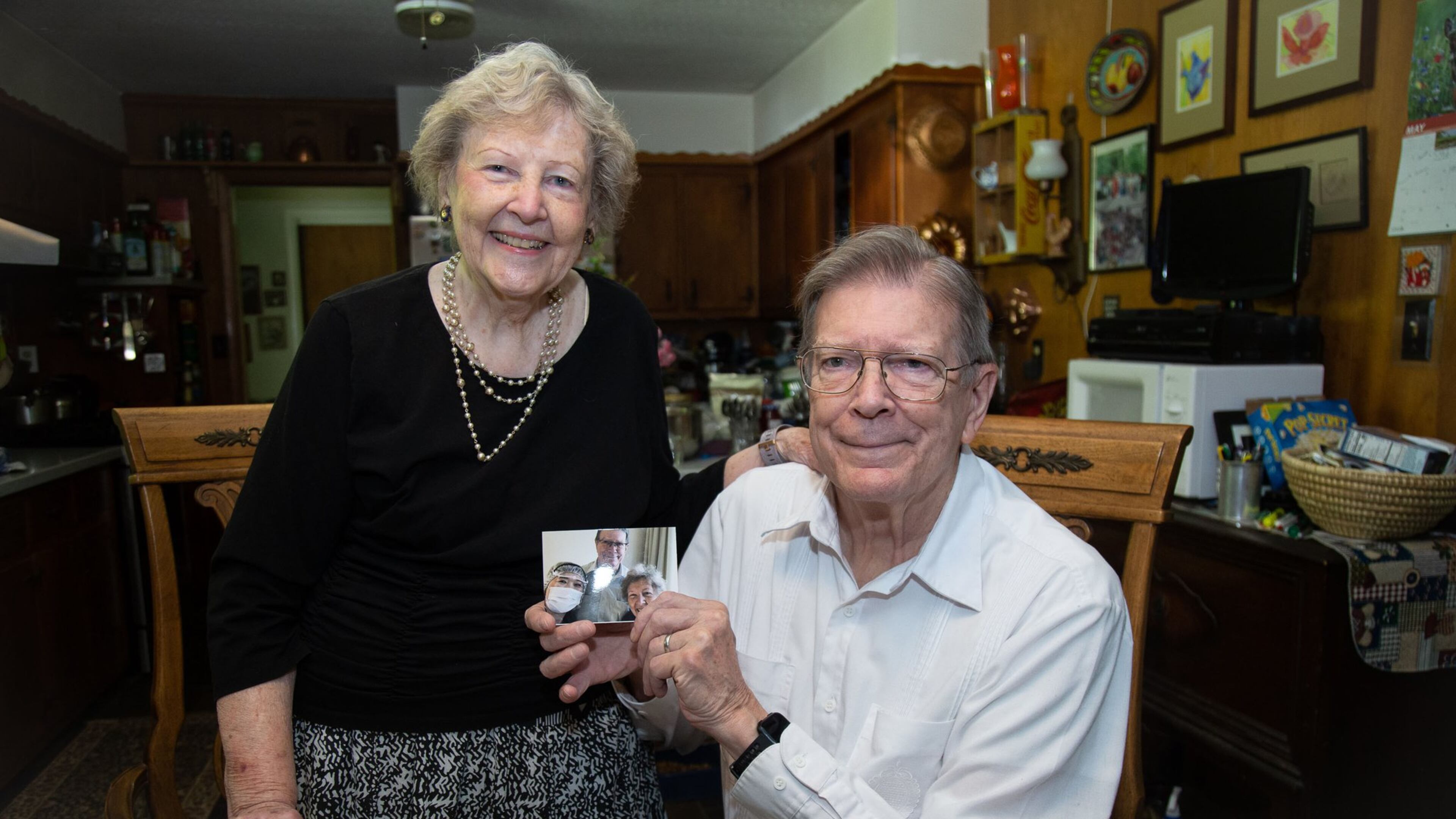 Clyde and Renee Smith hold a photograph of their Japanese medical staff that treated them after they tested positive for the coronavirus. The couple is known for their unwavering optimism. They remained hopeful throughout the experience.STEVE SCHAEFER / SPECIAL TO THE AJC
