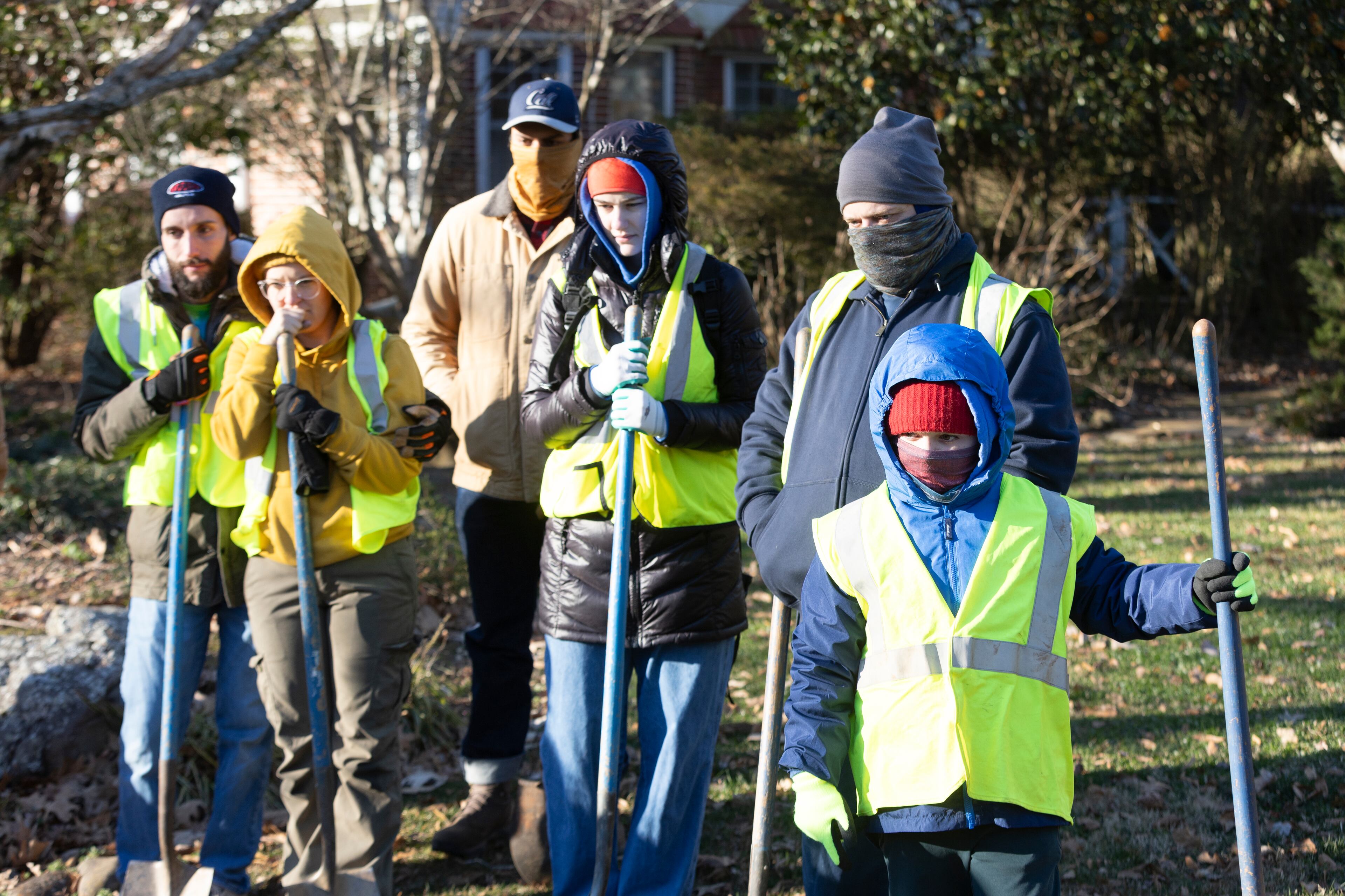 Trees Atlanta volunteers try to stay warm as they watch a demonstration on properly planting trees before they spread out around Avondale Estates on a cold Saturday morning, January 20, 2024. (Steve Schaefer/steve.schaefer@ajc.com)