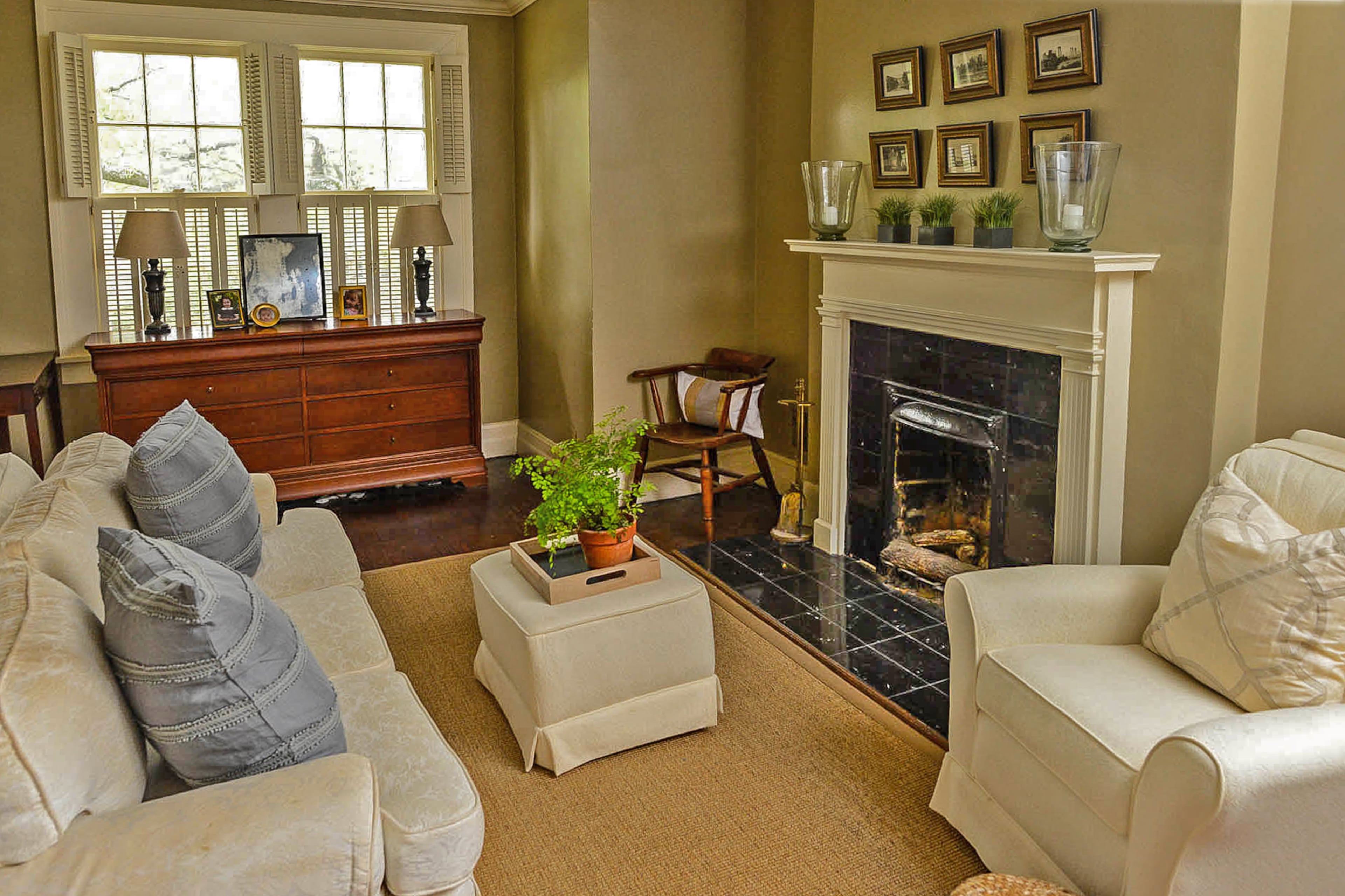 Kim and Thomas Rowe's master bedroom includes a sitting area with a fireplace with black marble and creamy furniture. The chair was originally used in the home's nursery, but was moved when their daughters grew older.