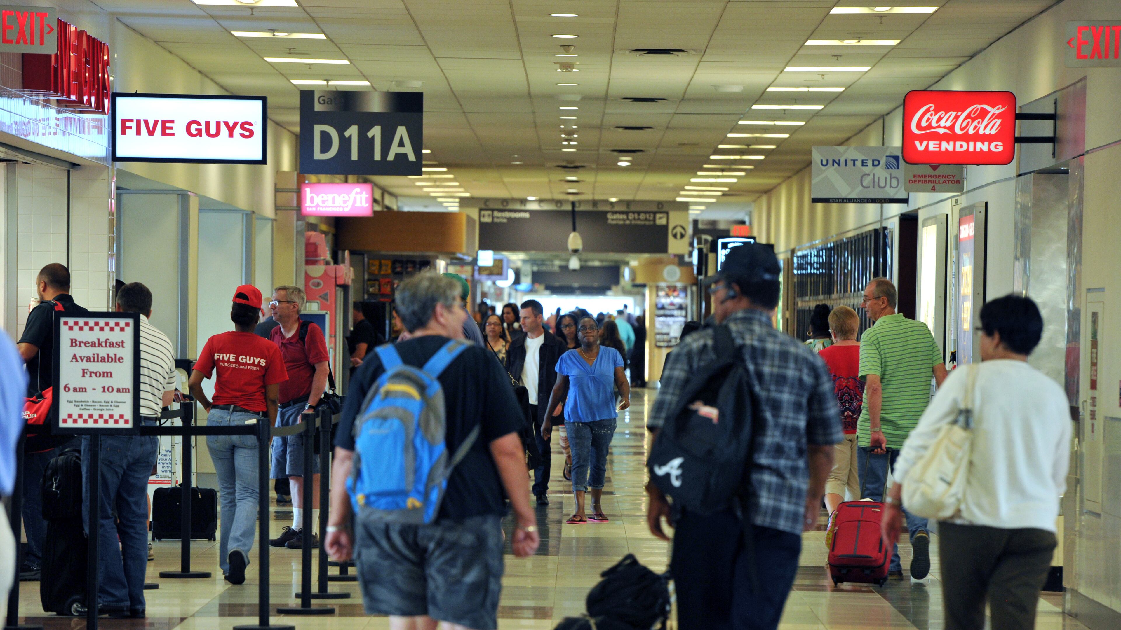 Airport travelers walk past one of newer restaurants, Five Guys, in Concourse D, Hartsfield-Jackson Atlanta International Airport on Tuesday, June 24, 2014. Hartsfield-Jackson and Delaware North celebrate the newest additions to Concourse D, including local favorites GrindHouse Killer Burgers and Yoforia, and national brands 40/40 Club and Food Network Kitchen. HYOSUB SHIN / HSHIN@AJC.COM Airport travelers can take advantage of Airport Restaurant Week in October. HYOSUB SHIN / HSHIN@AJC.COM