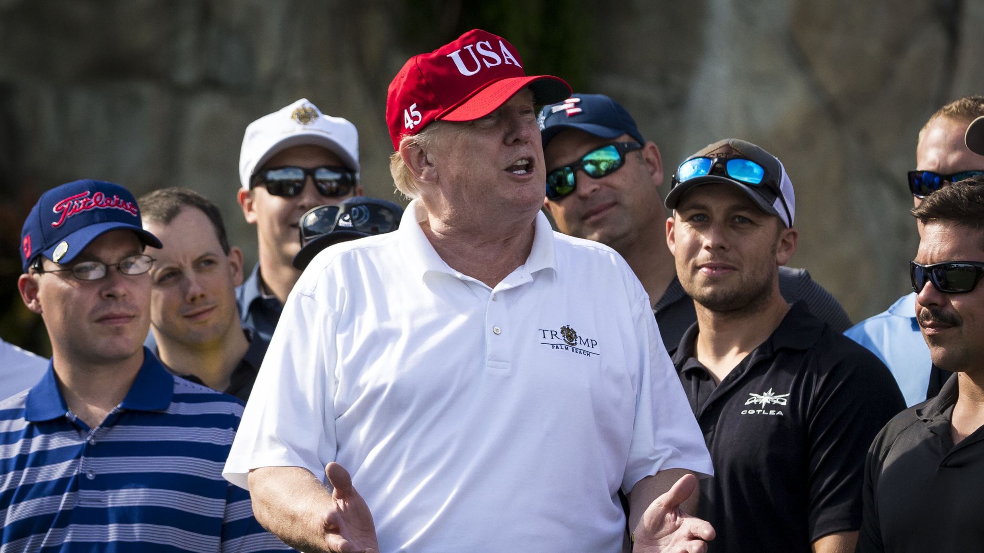 President Donald Trump with Coast Guard service members at his Trump National Golf Club in West Palm Beach, Fla., Dec. 29, 2017. About 60 service members participated in a four-man scramble tournament here Friday. (Al Drago/The New York Times)
