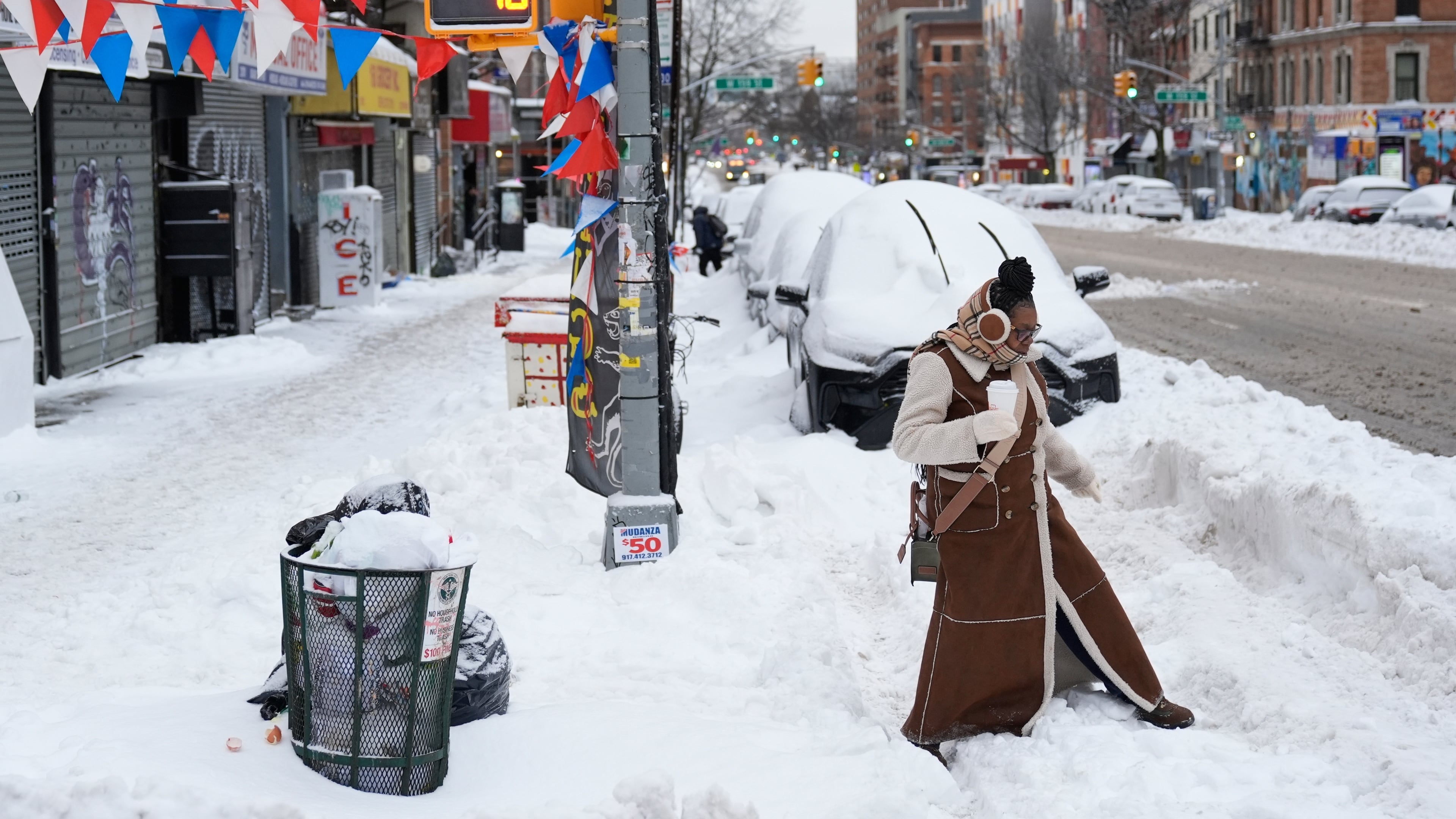 FILE - Carrie Hampton tries to navigate a snowy intersection without spilling her coffee in New York, Jan. 26, 2026. (AP Photo/Seth Wenig, File)