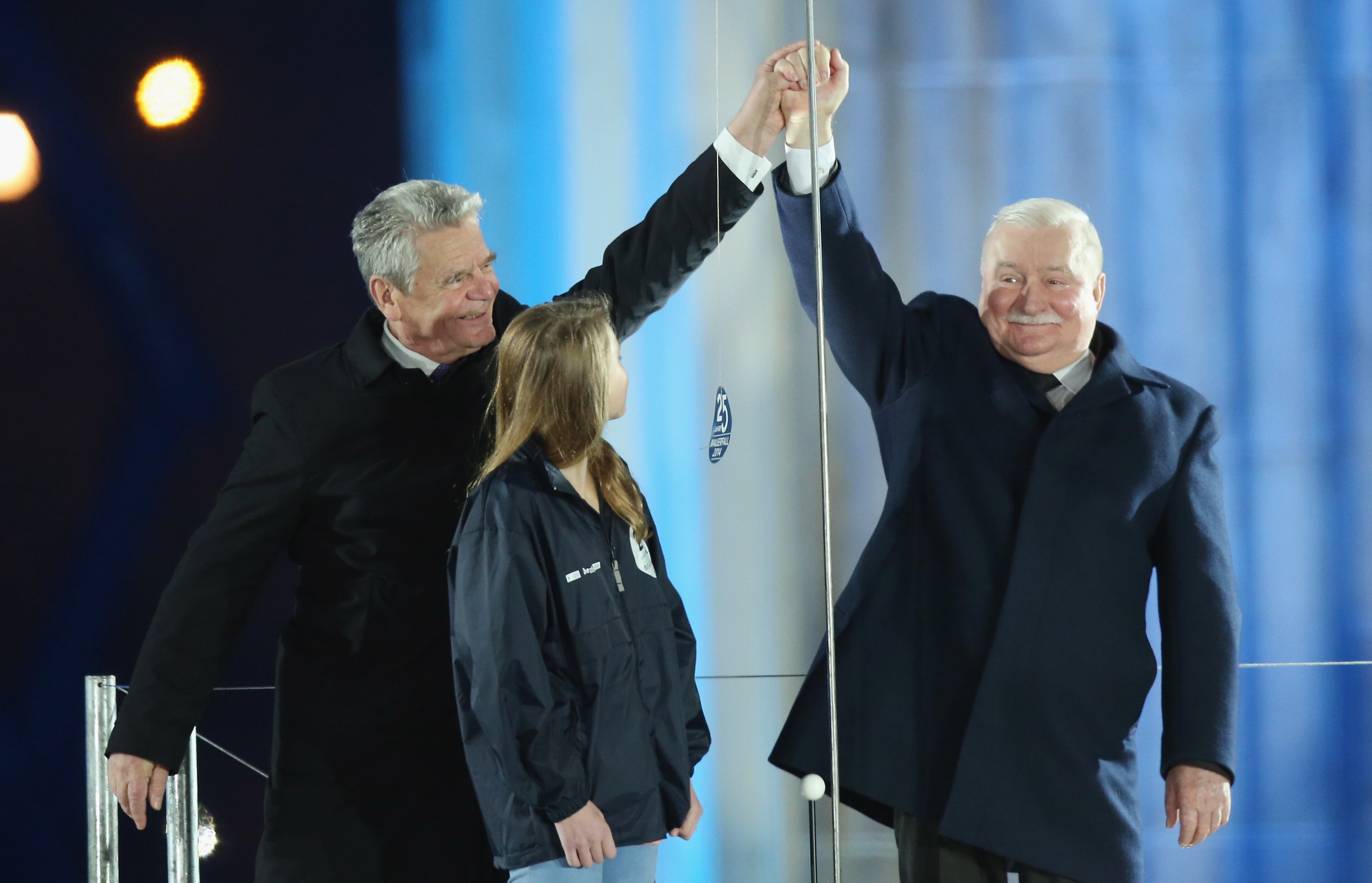 German President Joachim Gauck (L) greets former Polish President Lech Walesa at the Brandenburg Gate during celebrations on the 25th anniversary of the fall of the Berlin Wall on November 9, 2014 in Berlin, Germany. The city of Berlin is commemorating the 25th anniversary of the fall of the Berlin Wall with an installation of 6,800 lamps coupled with illuminated balloons along a 15km route where the Wall once ran and divided the city into capitalist West and communist East. The fall of the Wall on November 9, 1989, was among the most powerful symbols of the revolutions that swept through the communist countries of Eastern Europe and heralded the end of the Cold War. Built by the communist authorities of East Germany in 1961, the Wall prevented East Germans from fleeing west and was equipped with guard towers and deadly traps. (Photo by Sean Gallup/Getty Images)
