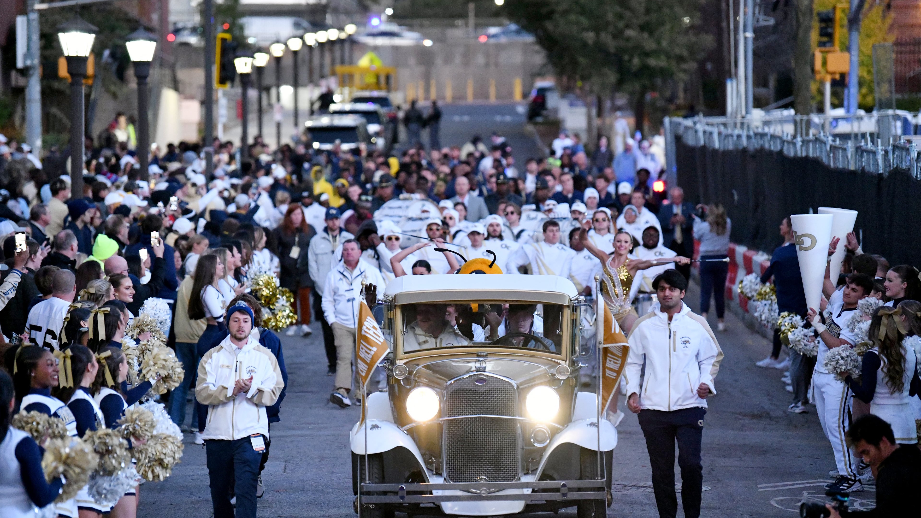 Georgia Tech's Ramblin' Wreck leads the band, cheerleaders, Buzz, players, and coaches walk down Yellow Jacket Alley prior to an NCAA college football game between Georgia Tech and North Carolina State at Bobby Dodd Stadium, Thursday, November 21, 2024, in Atlanta. (Hyosub Shin / AJC)