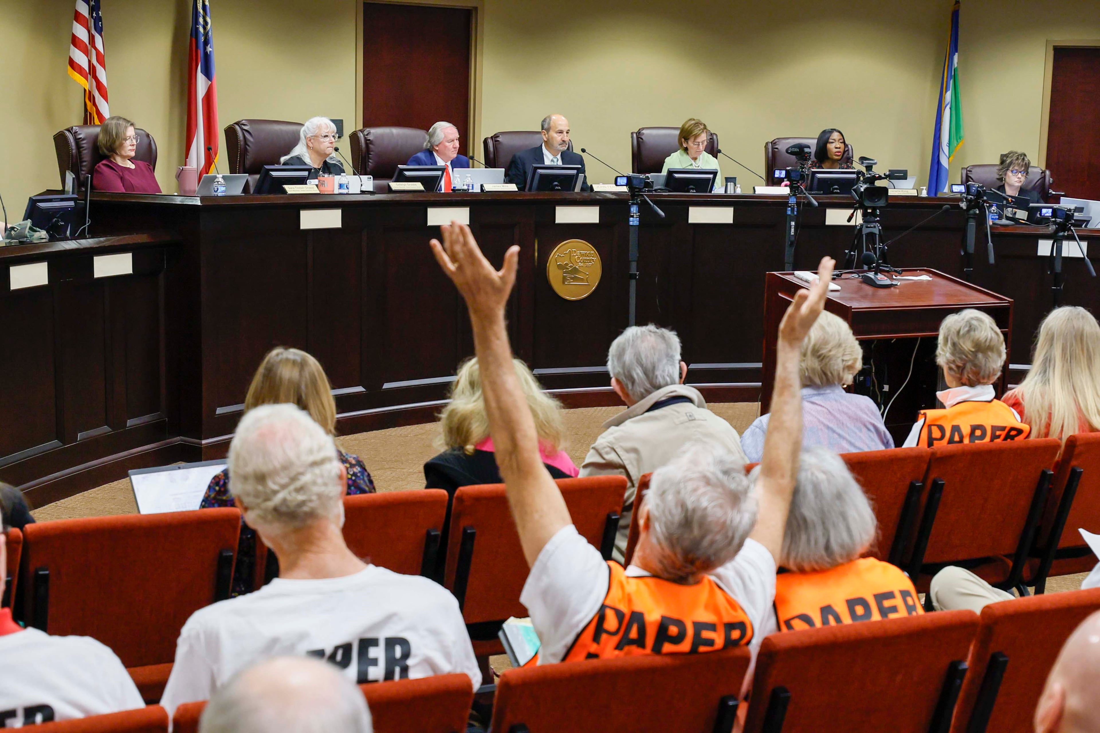 A supporter of paper ballots reacts as board members listen during a State Election Board meeting at Dawson County Government Center on Wednesday, April 15, 2026. (Miguel Martinez/AJC)
