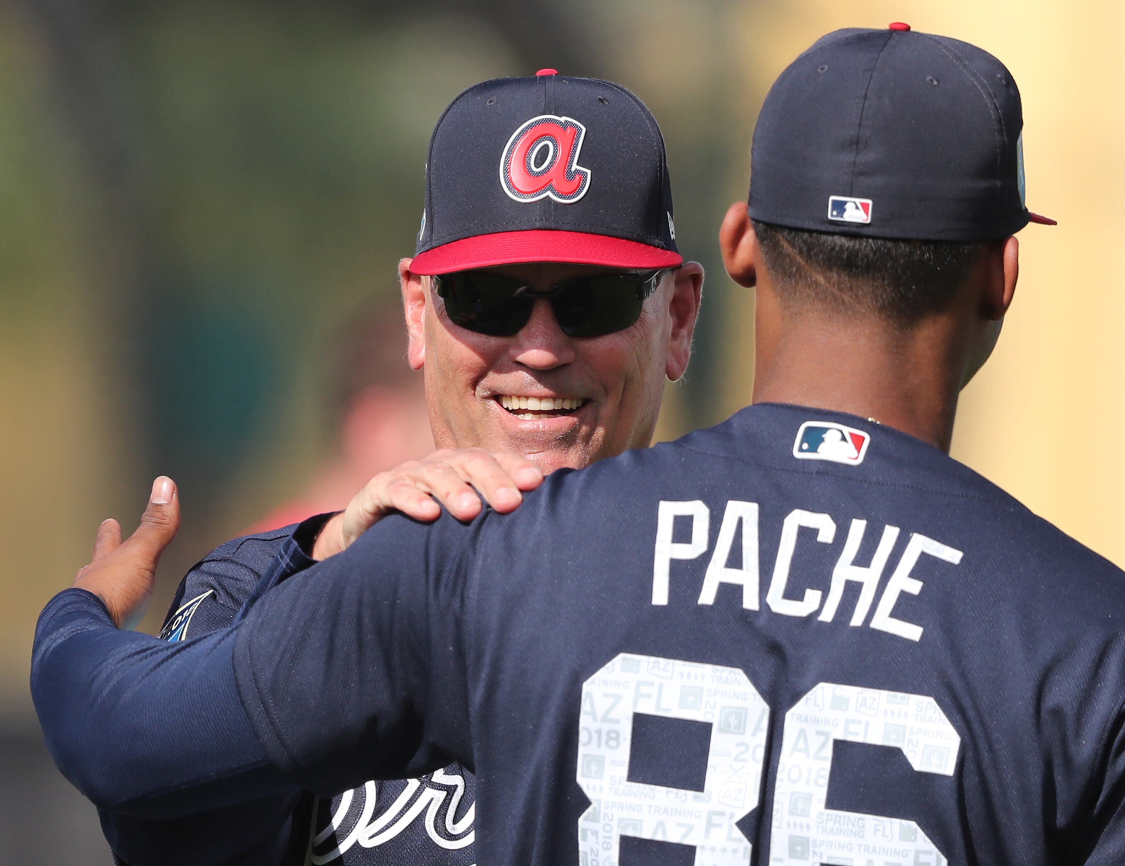 Braves manager Brian Snitker shares a laugh with outfielder Cristian Pache early in spring training. (Curtis Compton/ccompton@ajc.com)