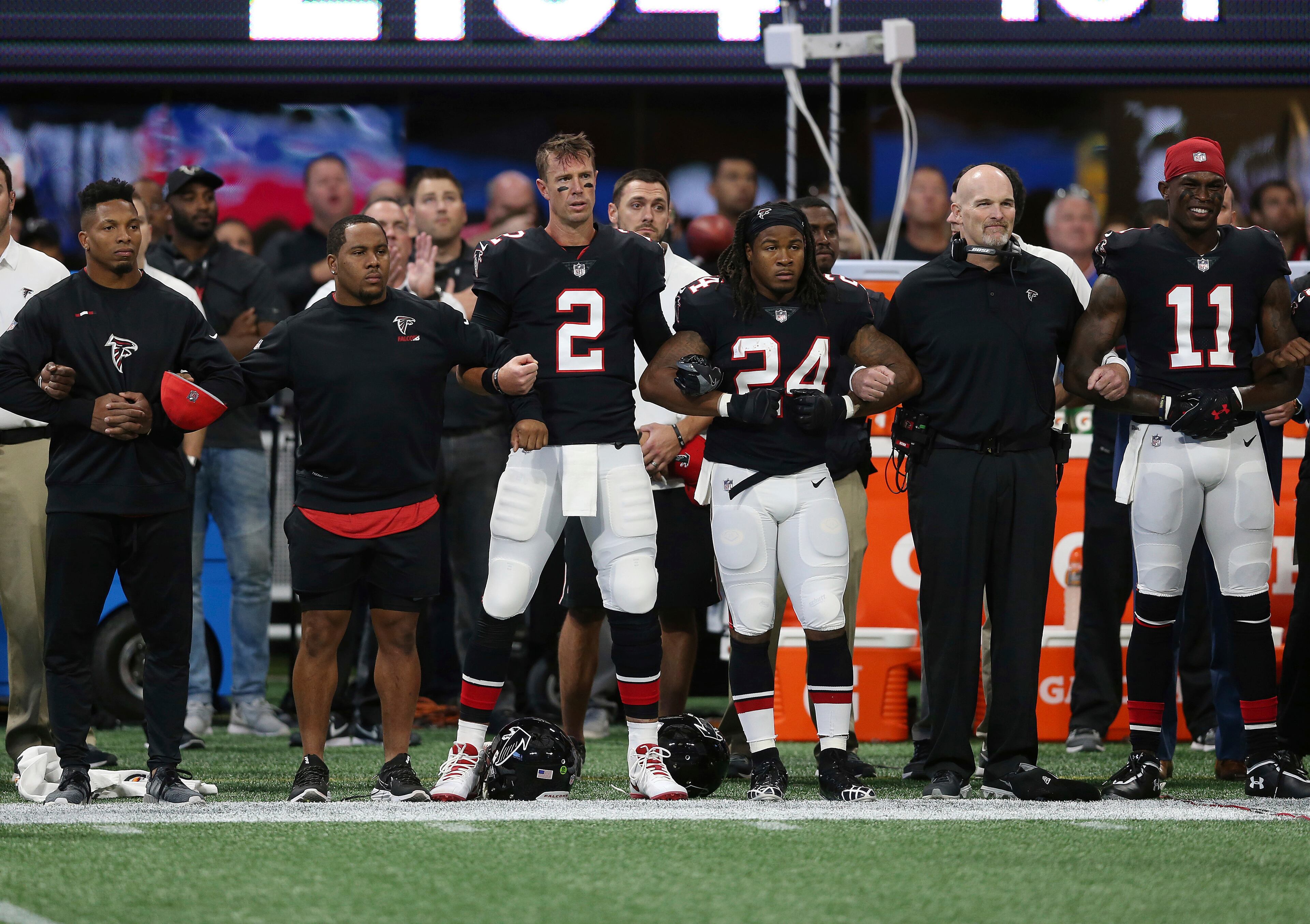 Atlanta Falcons stand arm-and-arm during the national anthem before the first half of an NFL football game between the Atlanta Falcons and the Buffalo Bills, Sunday, Oct. 1, 2017, in Atlanta. (AP Photo/John Bazemore)
