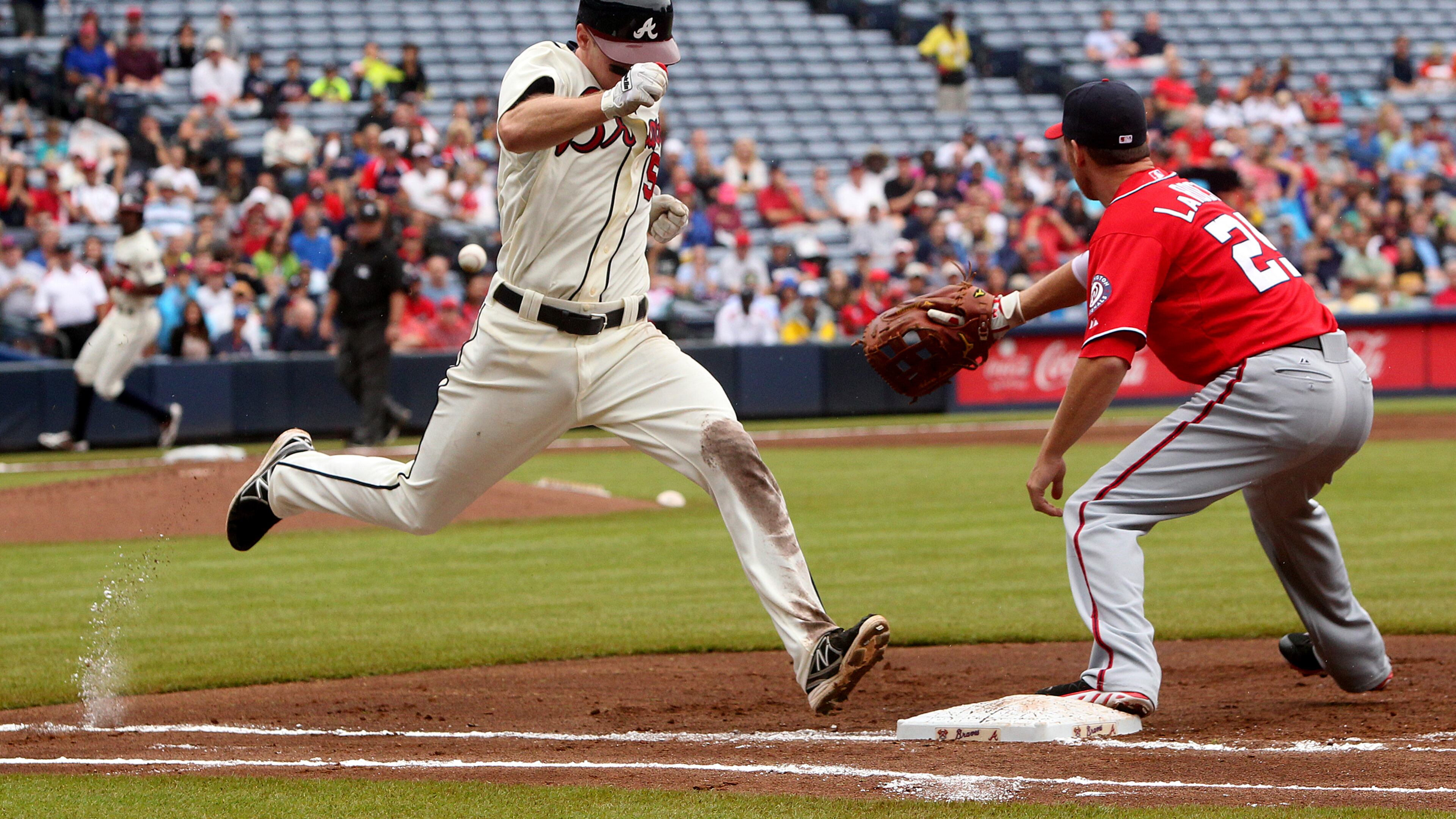 The Braves' Phil Gosselin beats out the throw to Nationals player Adam Laroche to reach first on a bunt during the first inning of their MLB game at Turner Field on Sunday in Atlanta.