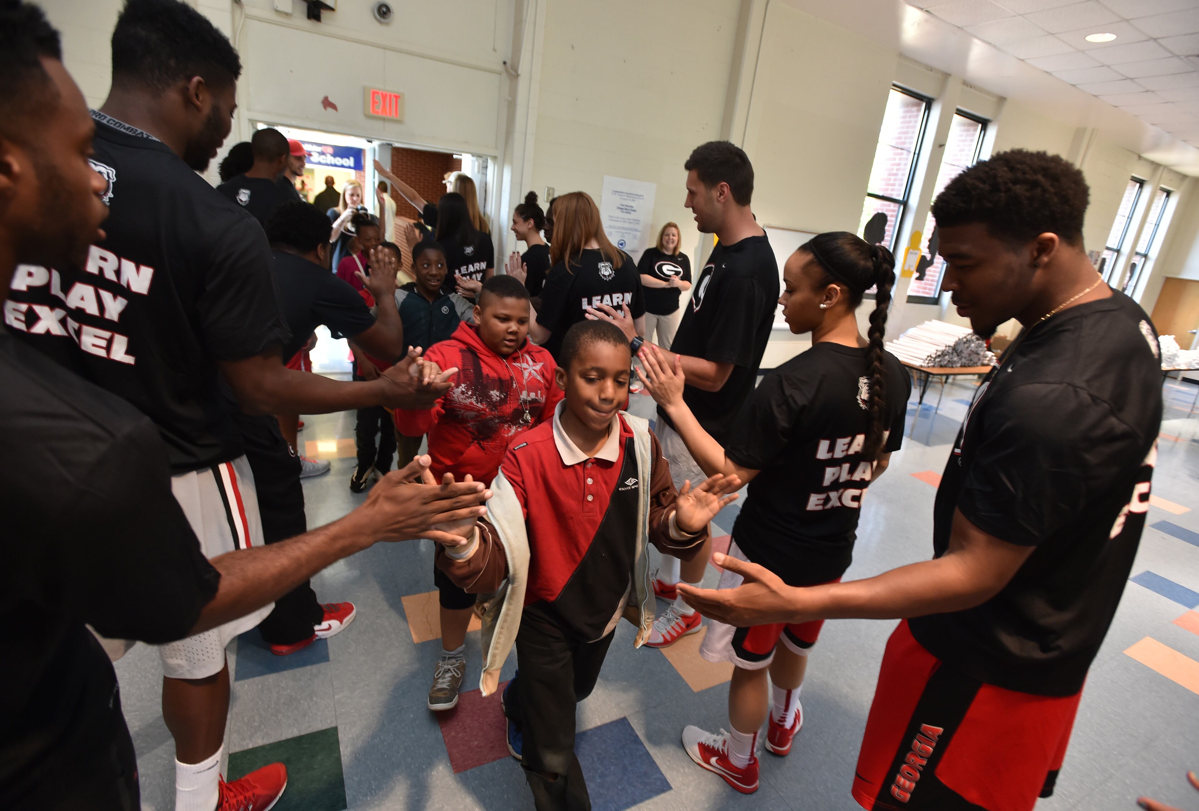 UGA student-athletes greet students as they enter the gym at D.H. Stanton Elementary School Wednesday May 6, 2015. Athletes representing 11 different sports, from the University of Georgia visited D.H Stanton Elementary School in Atlanta Wednesday as part of their annual UGA Day- Learn, Play, Excel initiative.