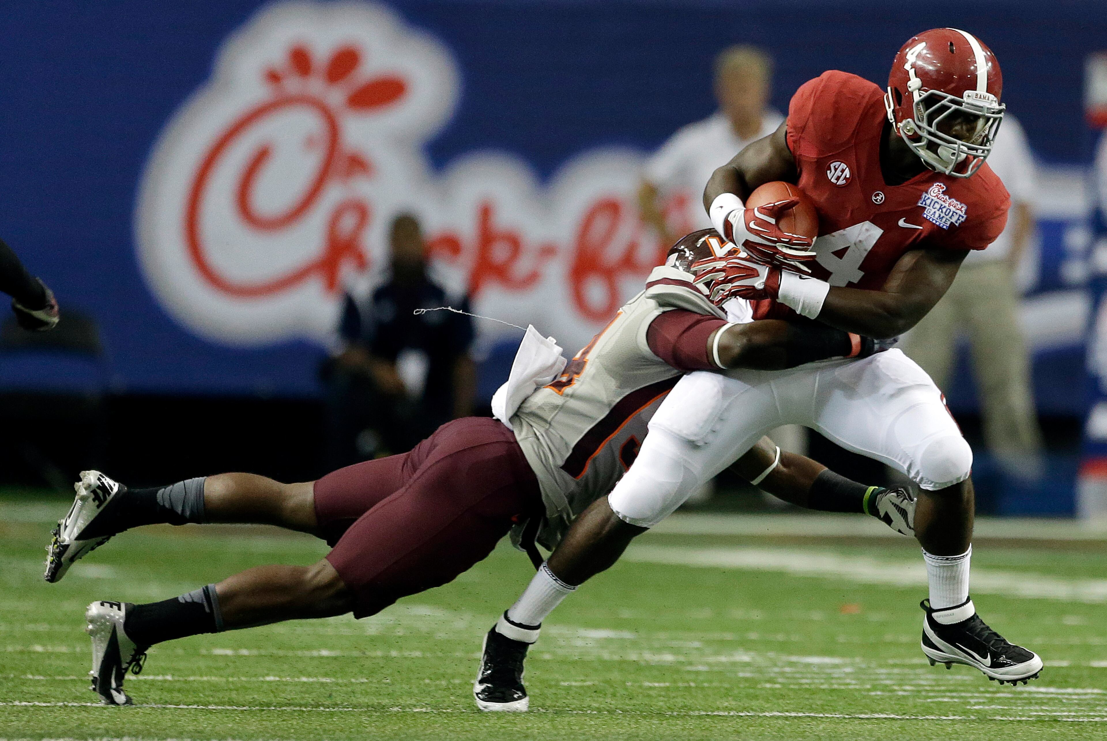 Virginia Tech safety Kyshoen Jarrett (34) tackles Alabama running back T.J. Yeldon (4)in the first half of an NCAA college football game, Saturday, Aug. 31, 201, in Atlanta. (AP Photo/Dave Martin)