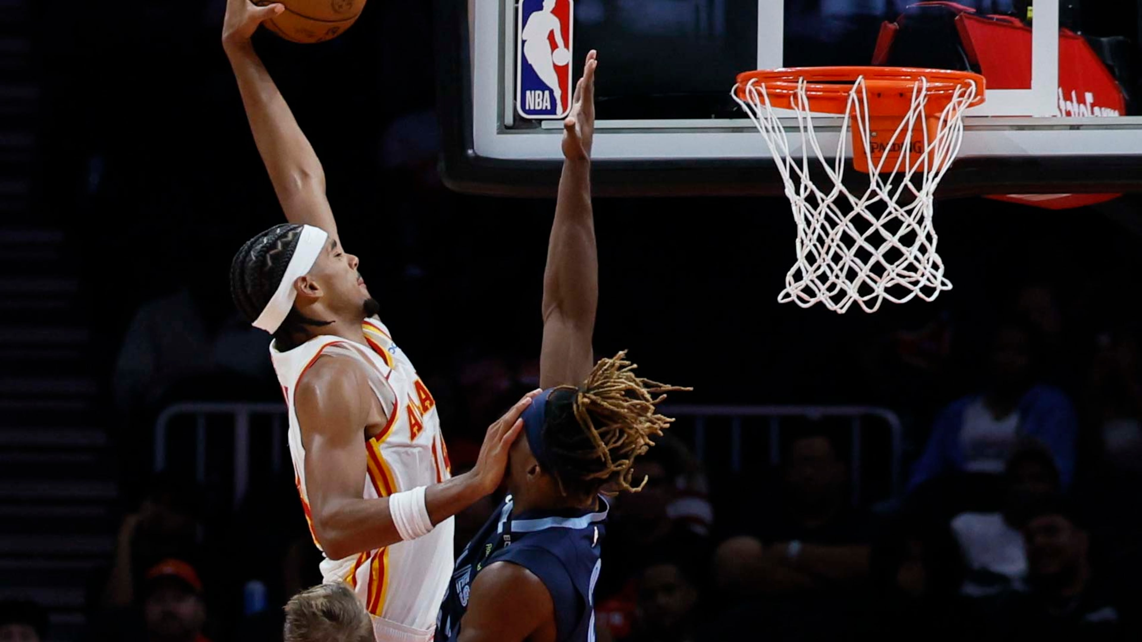 Hawks forward Asa Newell (left) dunks over Grizzlies guard Jahmai Mashack during their preseason game Monday, Oct. 5, 2026, at State Farm Arena in Atlanta. Newell averaged 5.2 points and 2.2 rebounds in 44 games with Atlanta last season. (Miguel Martinez/AJC)