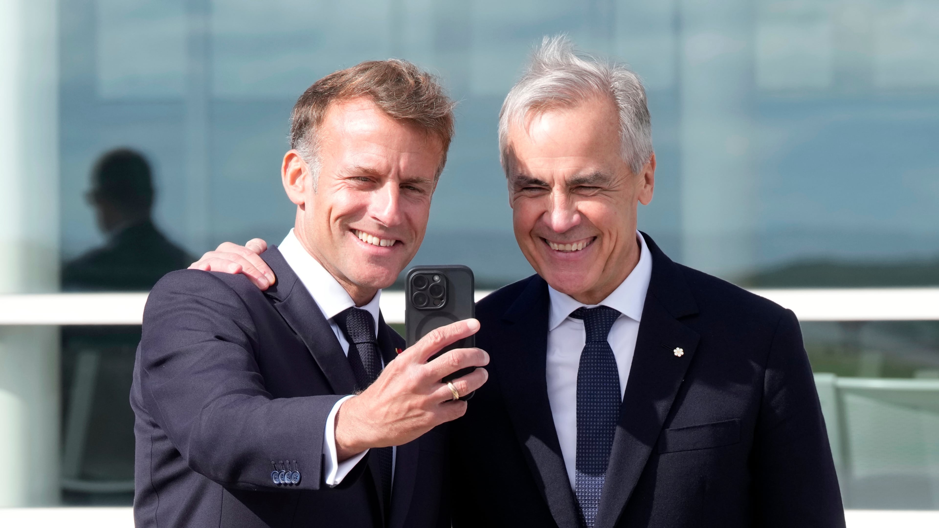 French President Emmanuel Macron, left, takes a selfie with Canadian Prime Minister Mark Carney after delivering remarks in Saint-Pierre, Saint-Pierre-et-Miquelon, Sunday, Sept.20, 2026. (Adrian Wyld/The Canadian Press via AP)