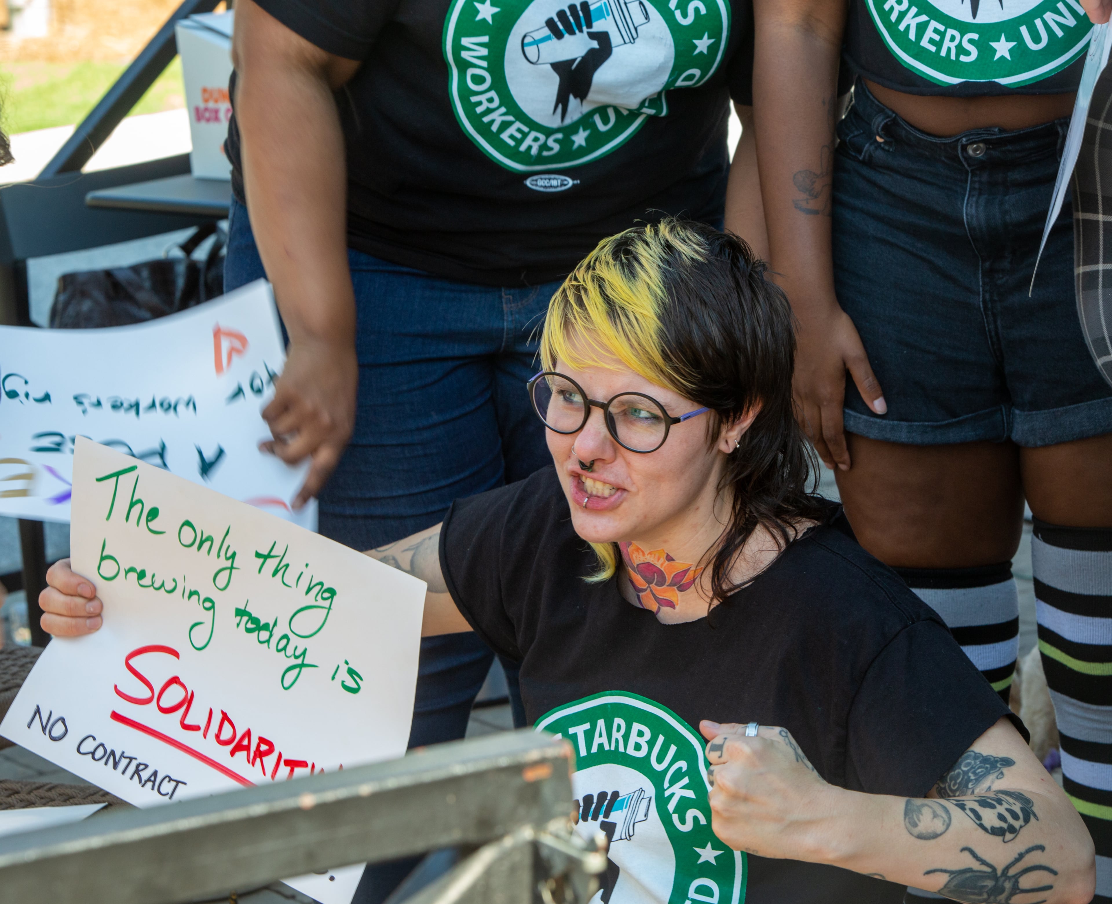 Starbucks employees, union workers and former Starbucks employees, including Snow Rindfleisch, a store manager at the Howell Mill location is on strike Sunday, July 17, 2022 after voting to join the union and asking for guaranteed work hours, benefits and a contract to protect the hourly workers. Starbucks management has not responded to requests to start negotiation. (Jenni Girtman for The Atlanta Journal-Constitution)