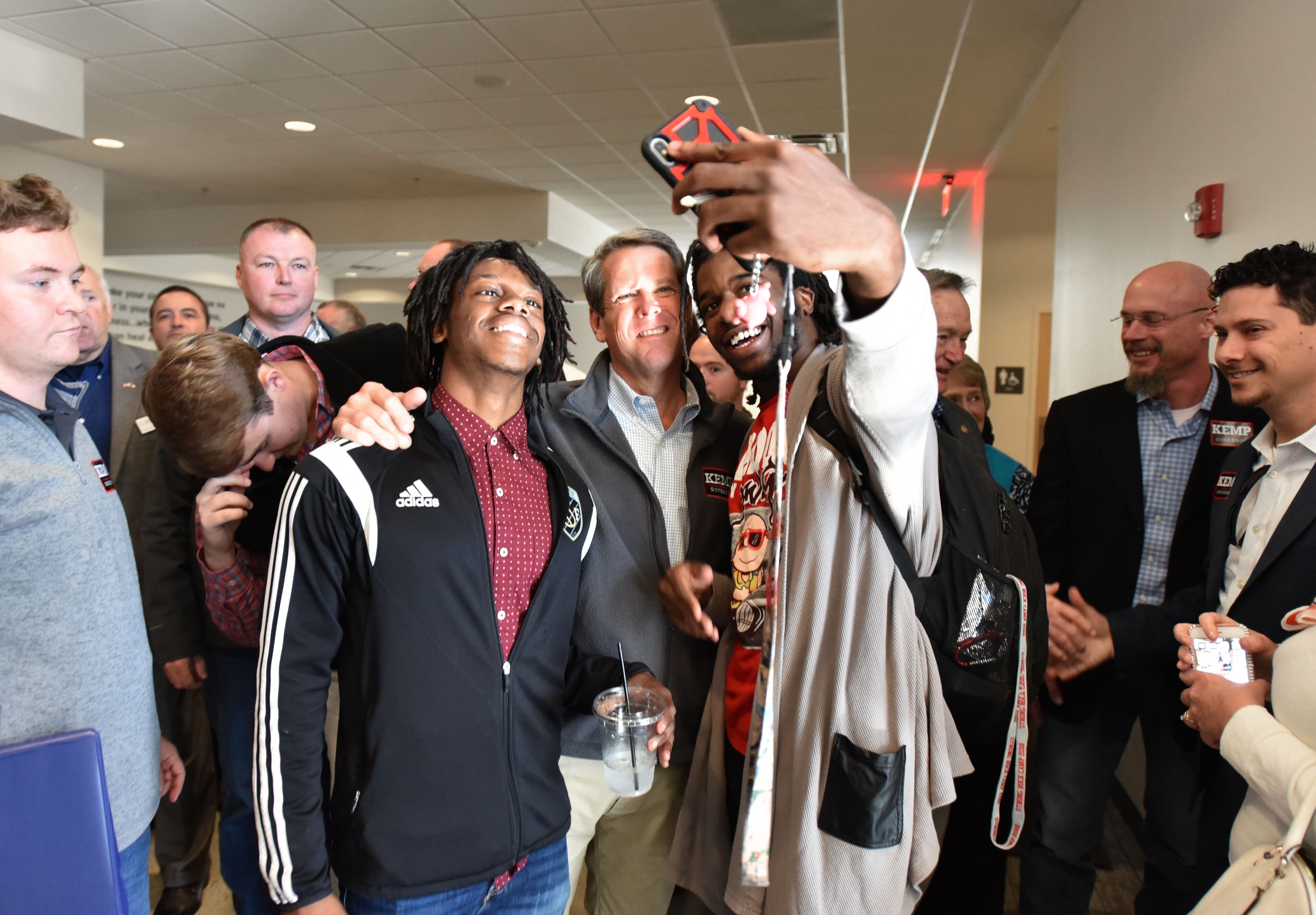 October 30, 2018 Cleveland - GOP gubernatorial candidate Brian Kemp poses with students as they take a selfie at Truett McConnell University in Cleveland during the second day of The Georgia Republican Party "Road to Victory" Bus Tour on Tuesday, October 30, 2018. Brian Kemp's stops in Cumming and Woodstock attracted hundreds of voters. Democrats have put a bullseye on the close-in suburbs, which were once solidly conservative but transformed into swingier territory with Donald Trumpâs victory. HYOSUB SHIN / HSHIN@AJC.COM