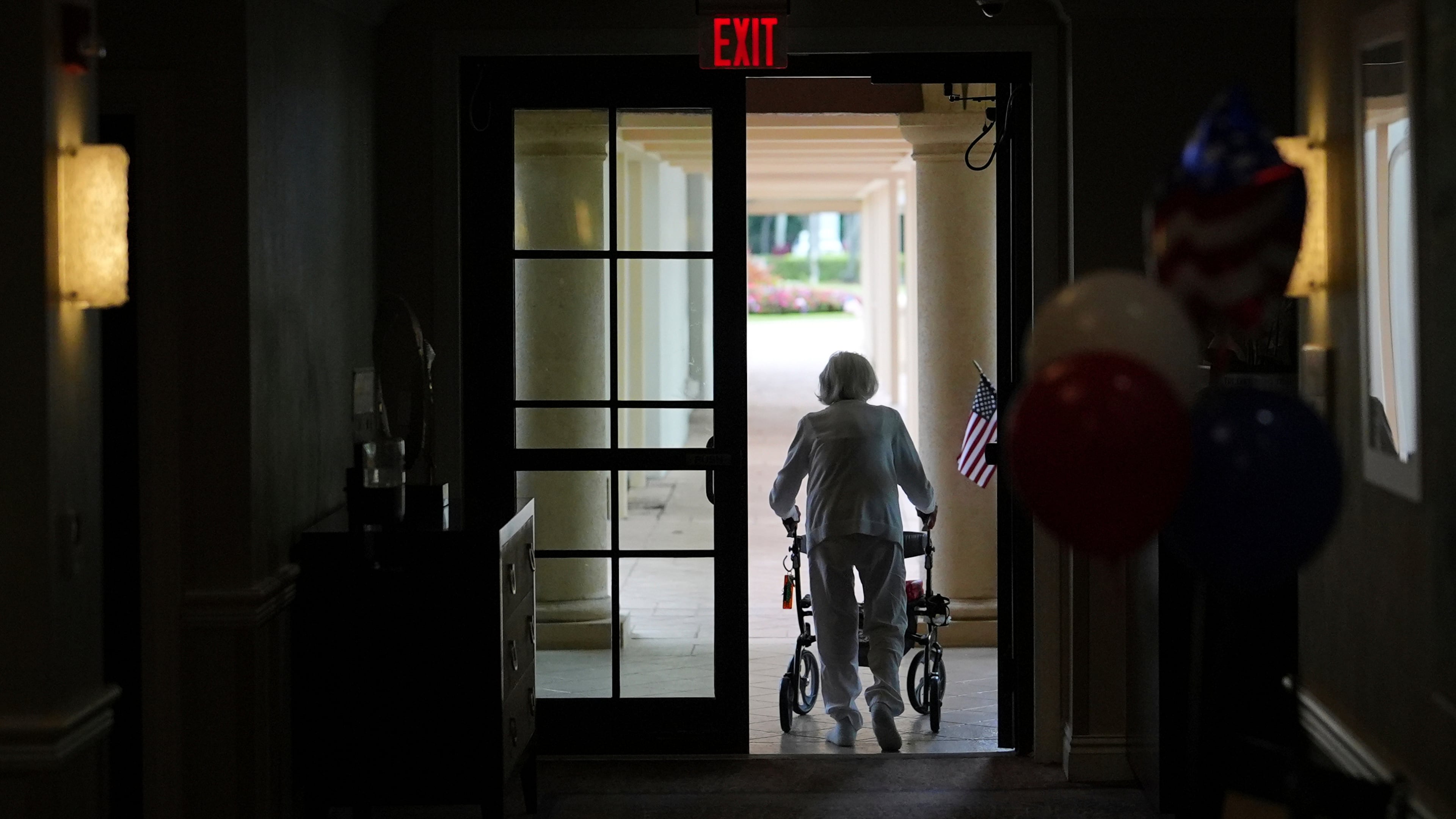 FILE - A woman uses a walker as she exits an assisted living building, July 4, 2025, in Boca Raton, Fla. (AP Photo/Rebecca Blackwell, File)