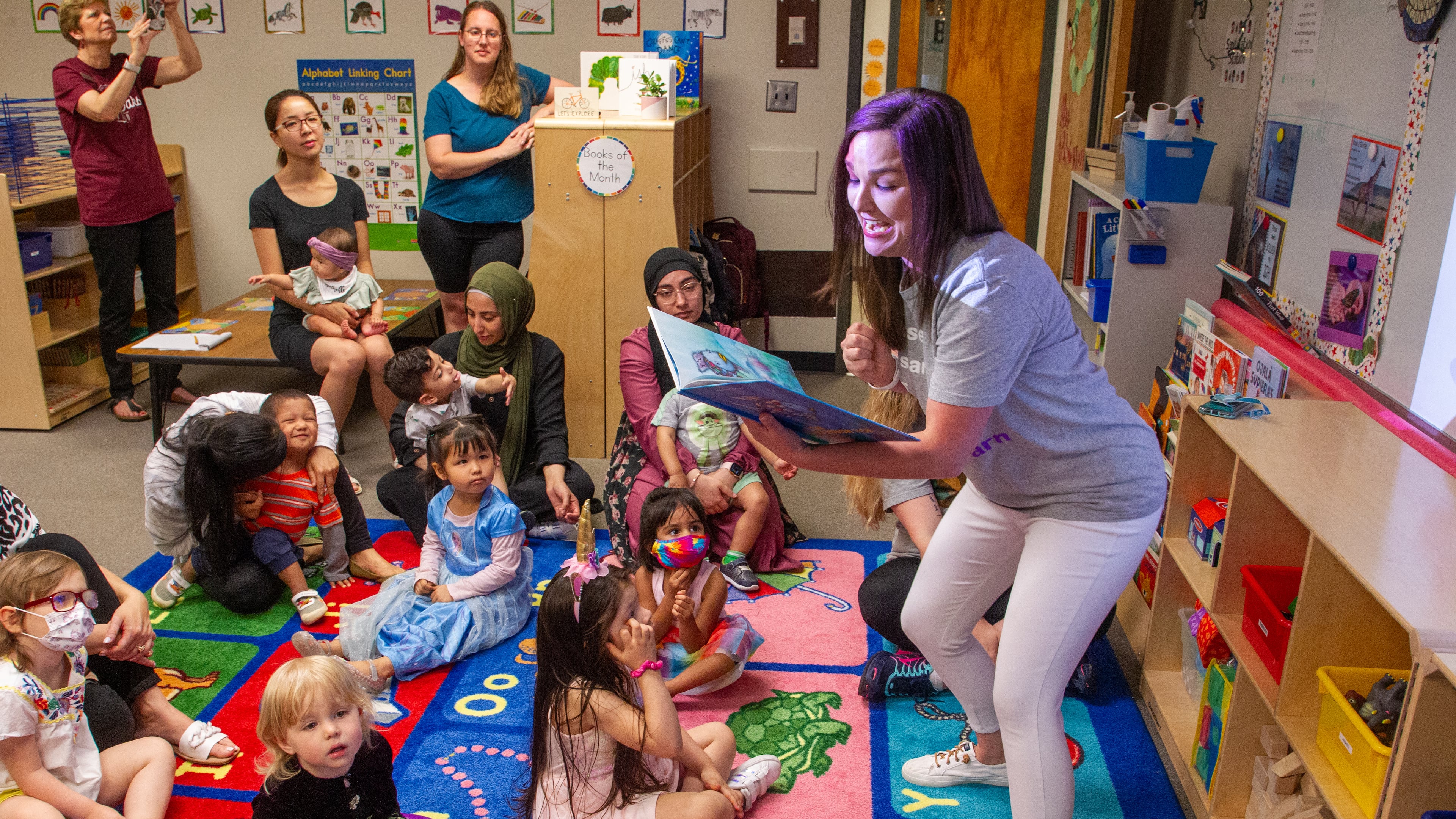 Teacher Emily Broich reads aloud to her kids and their mothers at B.B. Harris Elementary school in Duluth Friday May 13, 2022. (Steve Schaefer / steve.schaefer@ajc.com)