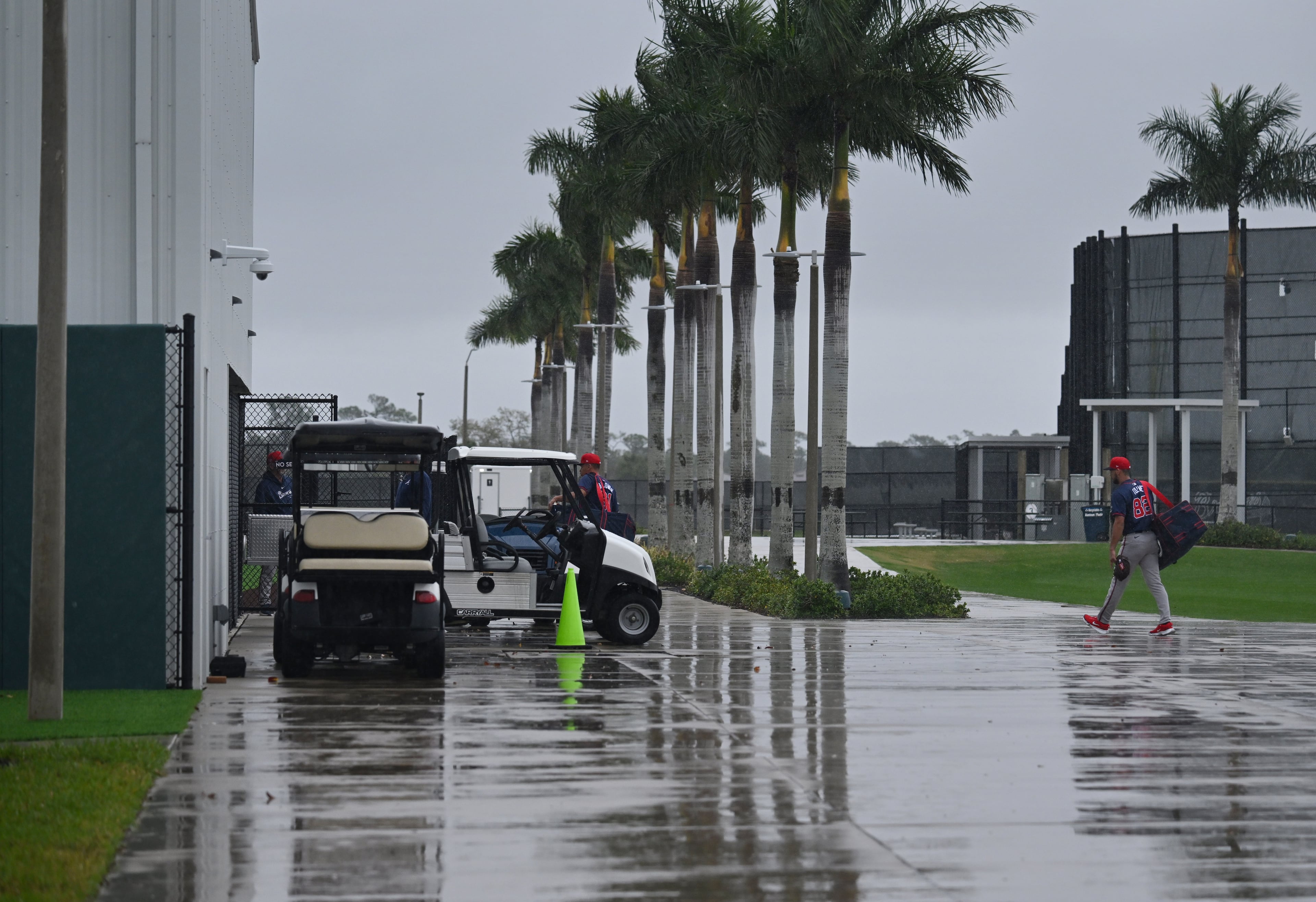 Atlanta Braves players rush to an indoor facility on a rainy day of spring training workouts at CoolToday Park, Sunday, Feb. 18, 2024, in North Port, Florida. (Hyosub Shin / Hyosub.Shin@ajc.com)