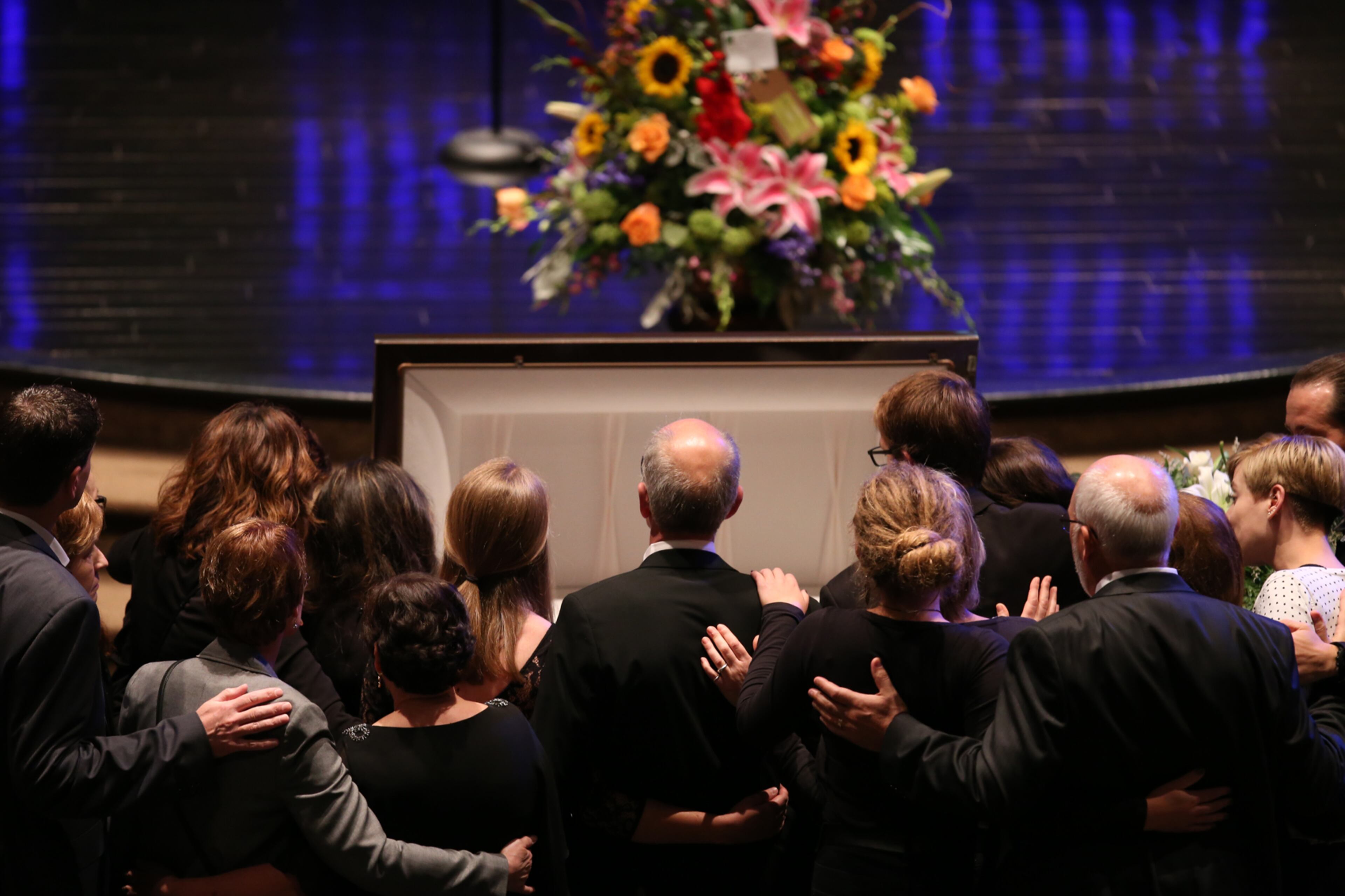 April 19, 2017, Atlanta, Georgia - Ron Herens' family and loved ones gather around the open casket and huddle together in Powder Springs, Georgia, on April 19, 2017. A Celebration of Life funeral service was held for Marietta Fire Fighter Ron Herens, who died in a traffic accident while on vacation in Los Angeles last week. (HENRY TAYLOR / HENRY.TAYLOR@AJC.COM)