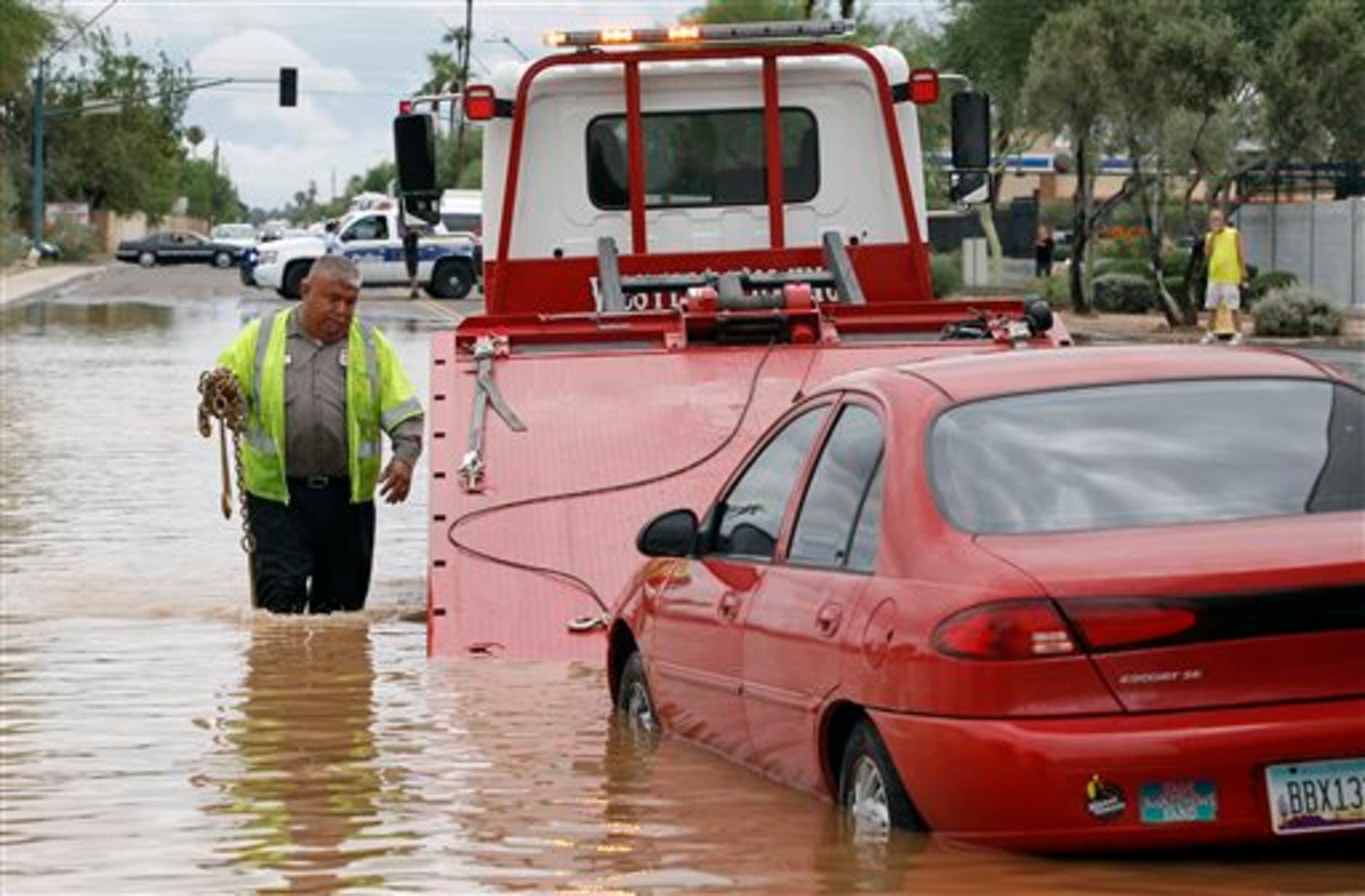 Steven Martinez of Western Towing prepares to lift a vehicle stranded in about two feet of water near Roosevelt and 44th Avenue on Monday, Sept. 8, 2014 in Phoenix. Monday's record breaking rainfall flooded several Phoenix-area freeways and local streets forcing closures with some areas reporting up to five inches of rain. (AP Photo/Ralph Freso)