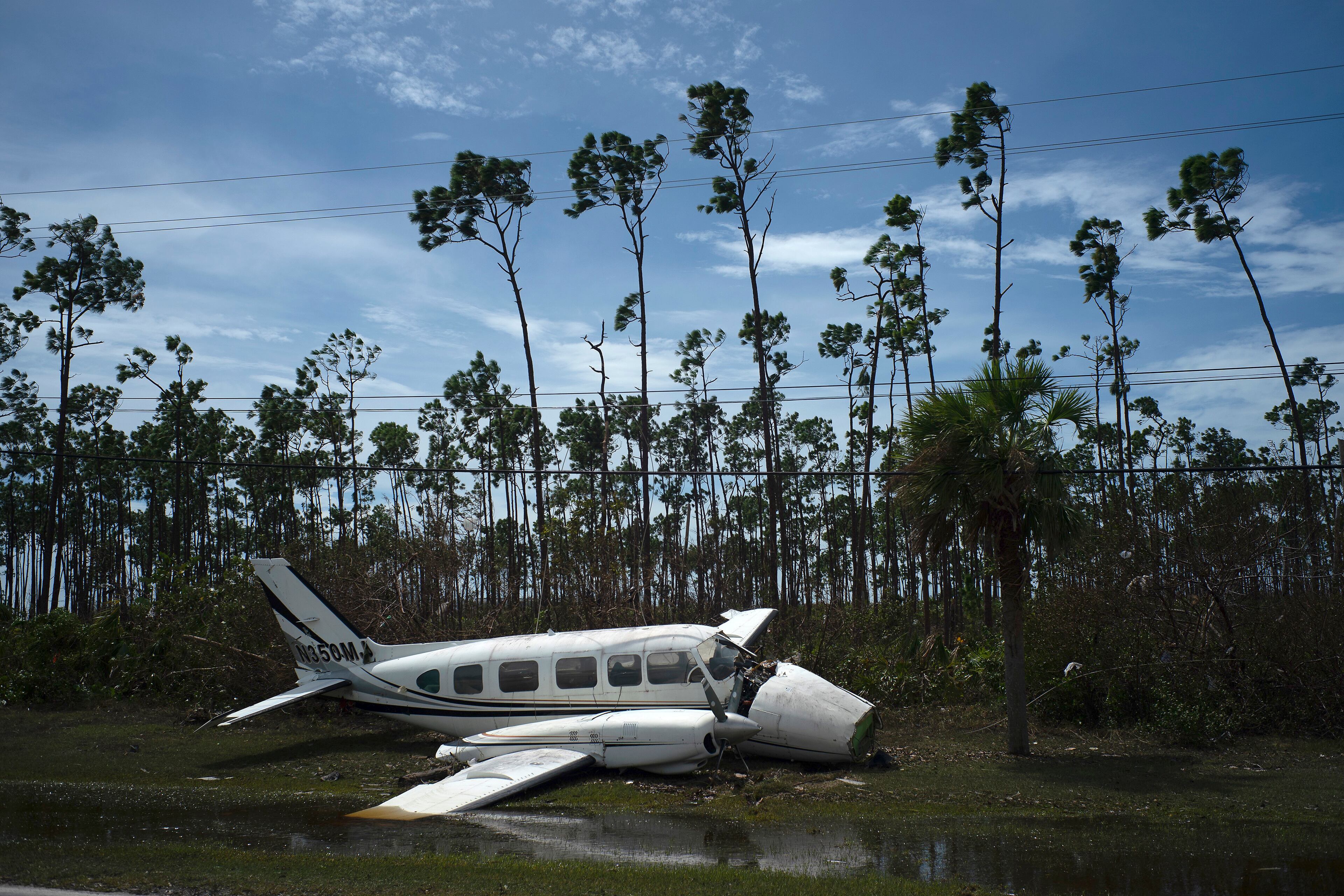 An airplane sits on the side of a road in the Pine Bay neighborhood, in the aftermath of Hurricane Dorian, in Freeport, Bahamas, Wednesday, Sept. 4, 2019. Rescuers trying to reach drenched and stunned victims in the Bahamas fanned out across a blasted landscape of smashed and flooded homes Wednesday, while disaster relief organizations rushed to bring in food and medicine. (AP Photo/Ramon Espinosa)