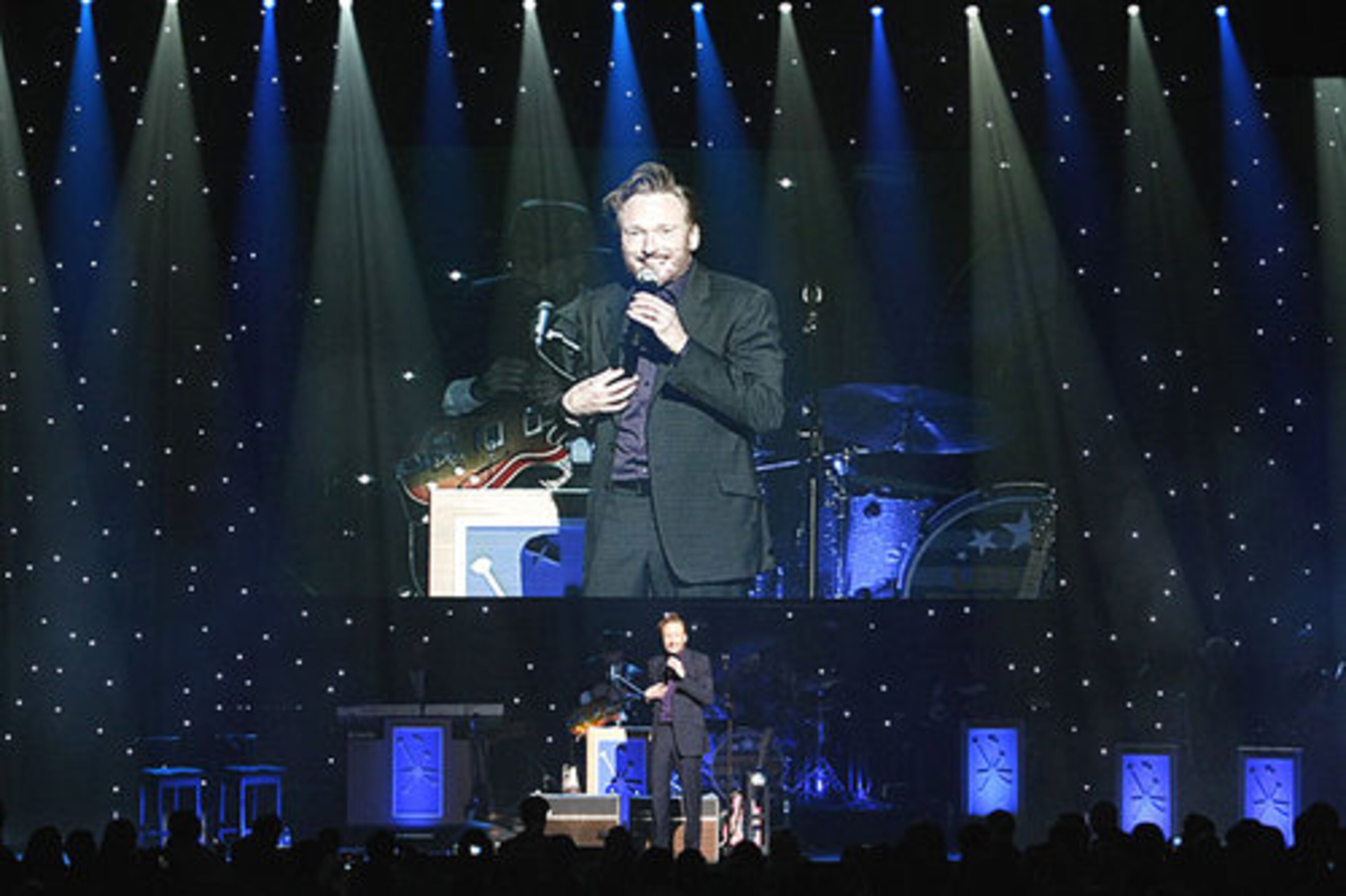 Stars light the stage and a giant screen mirrors his routine. Conan Christopher O'Brien, born April 18, 1963, is an American television host and comedian. He served as host of Late Night with Conan O'Brien from 1993 to 2009, followed by the short-lived The Tonight Show with Conan O'Brien from 2009 to 2010. Prior to his hosting career, O'Brien was a writer for Saturday Night Live and the animated series The Simpsons.